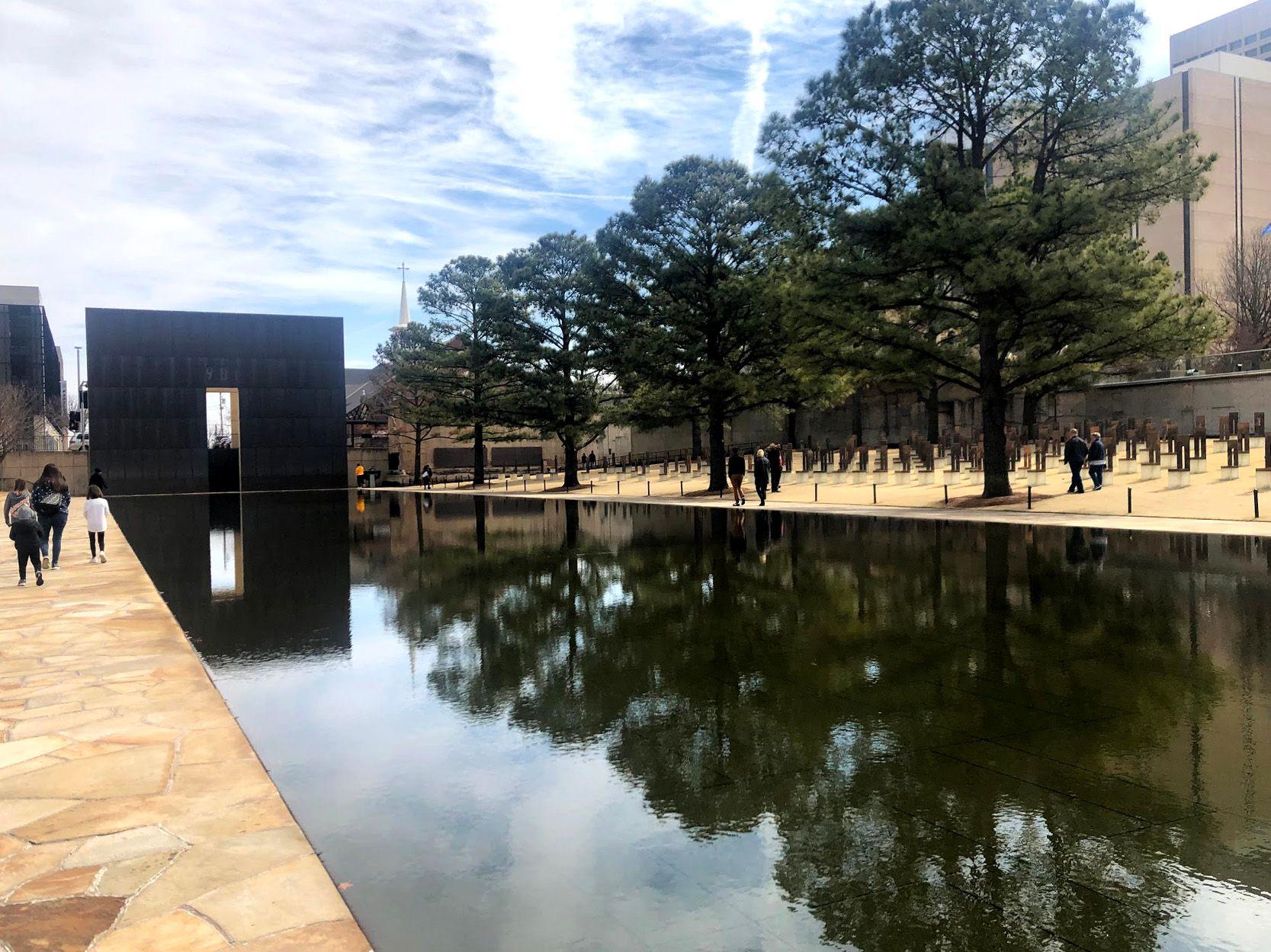 The National Memorial of the Oklahoma City Bombing. A black retangular arch reflect into a pool or water.