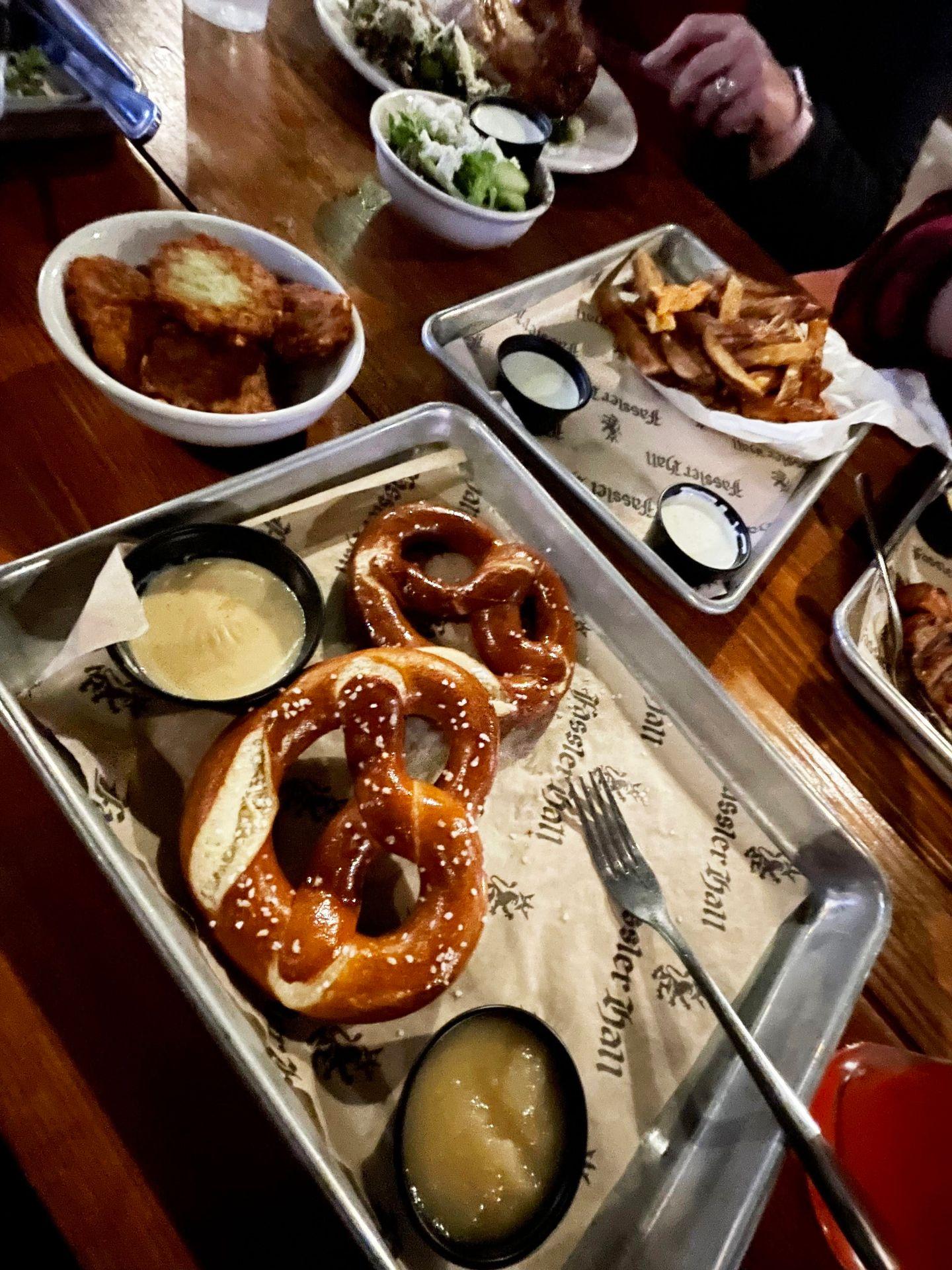 Plates of soft pretzels, fries and potato pancakes at Fassler Hall.