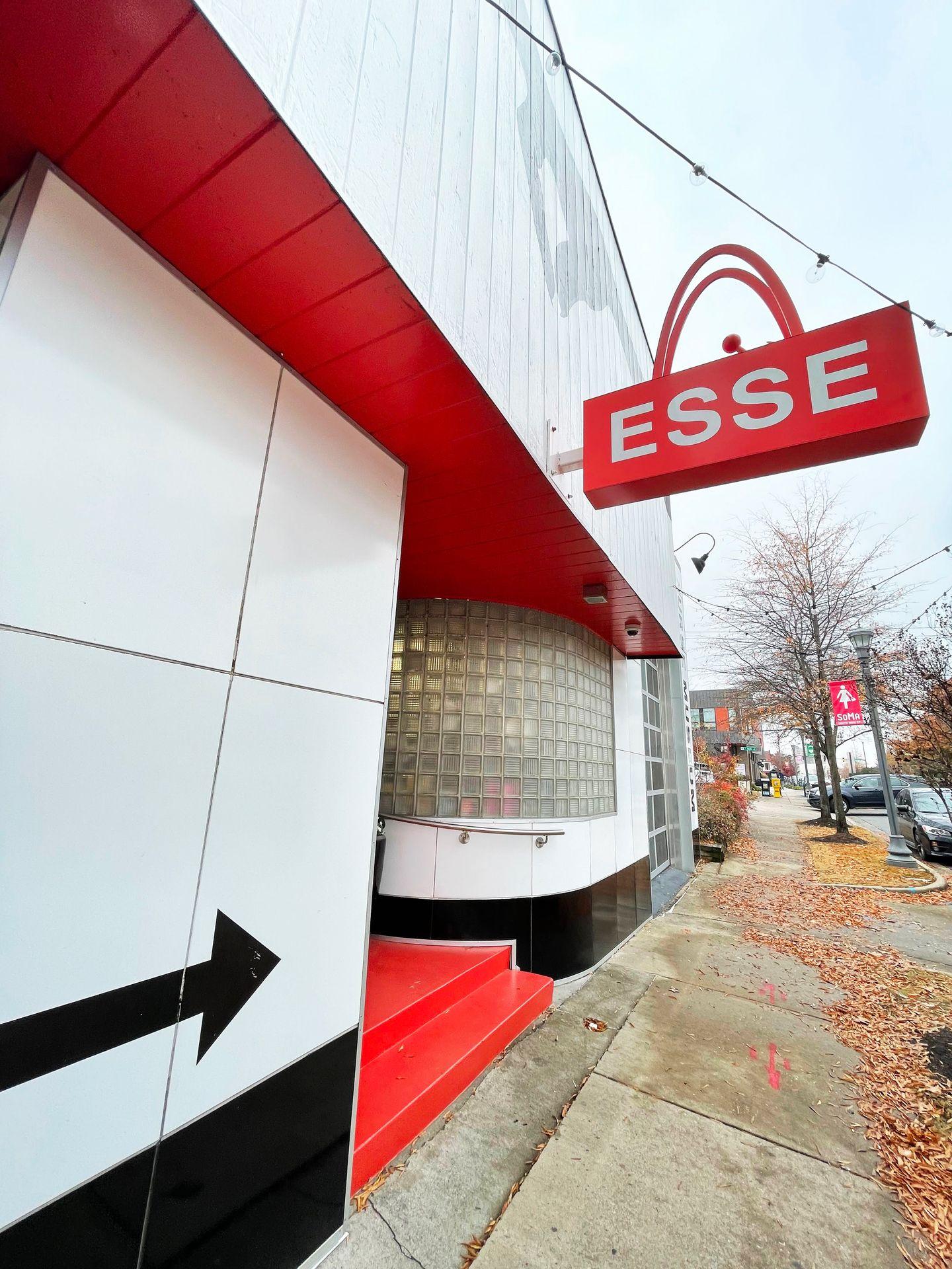 The outside of the Esse Purse Museum. The building is red and white and black arrow points to the door.