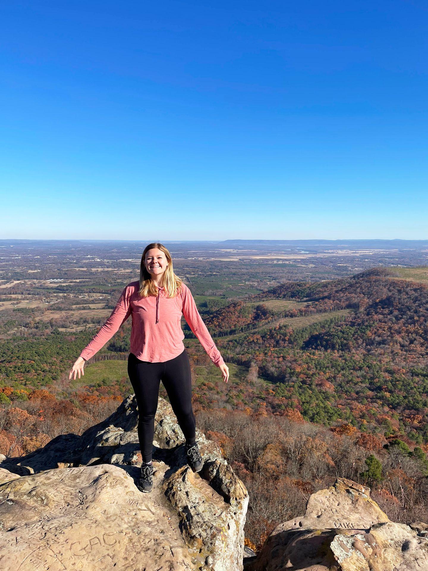A close view of Lydia standing on a rock with great views from Mount Nebo behind her.