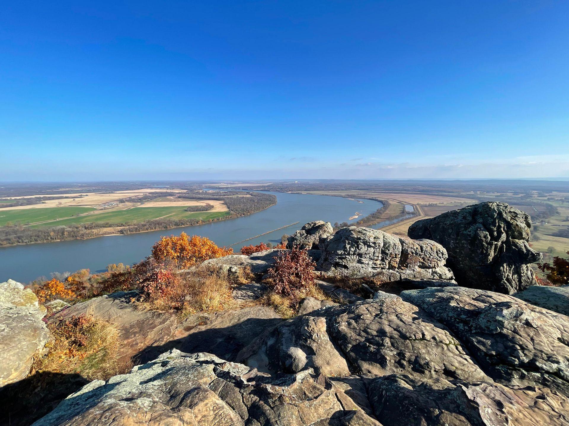 An area with boulders with a view of a curve in the Arkansas River down below.