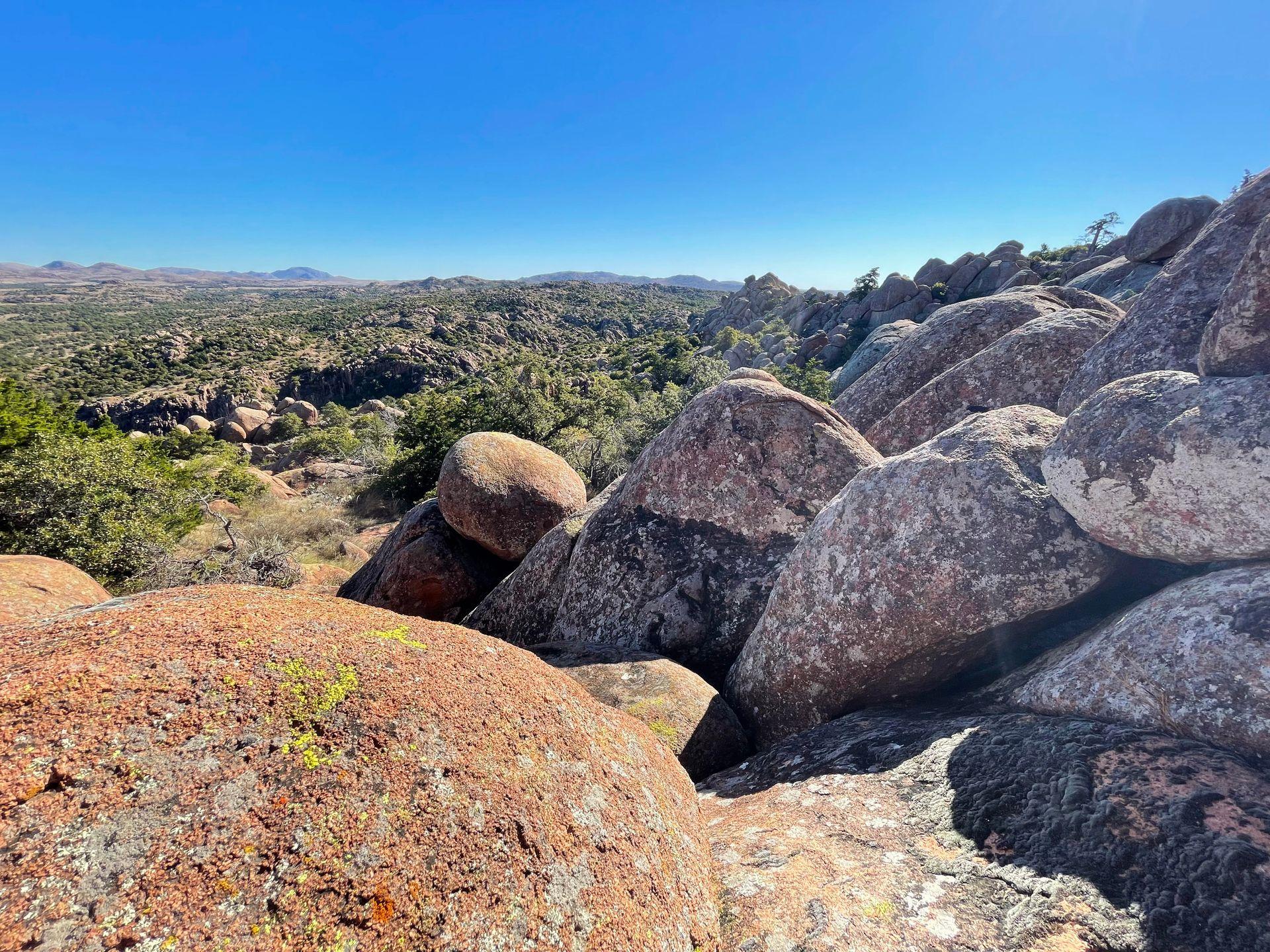 A view of boulders and trees in the distance from Mount Scott in the Wichita Mountains of Oklahoma.