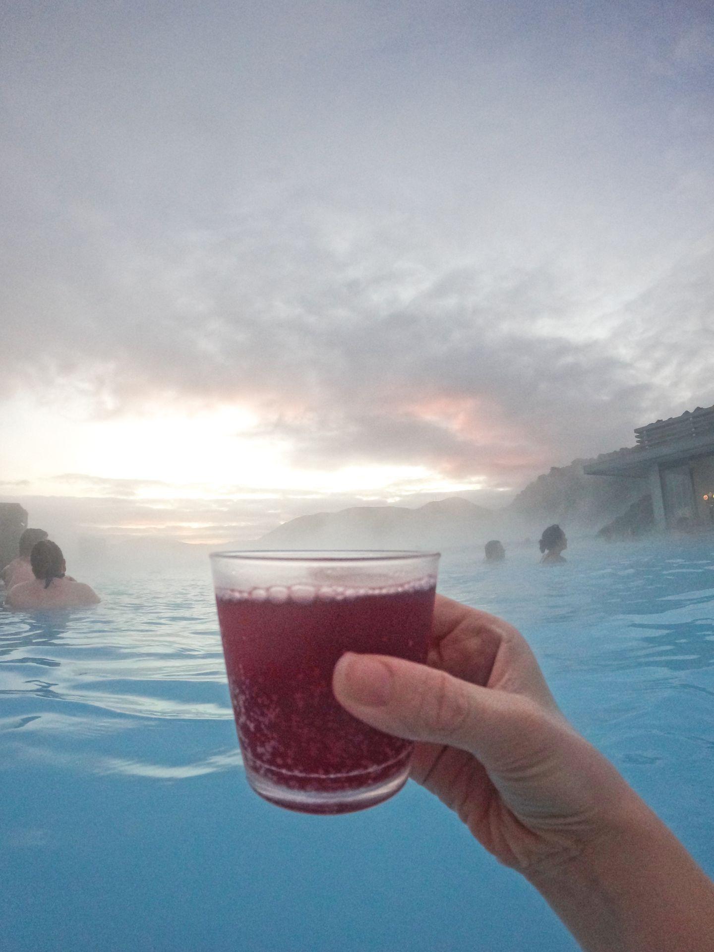 A red cocktail being held up at the Blue Lagoon.