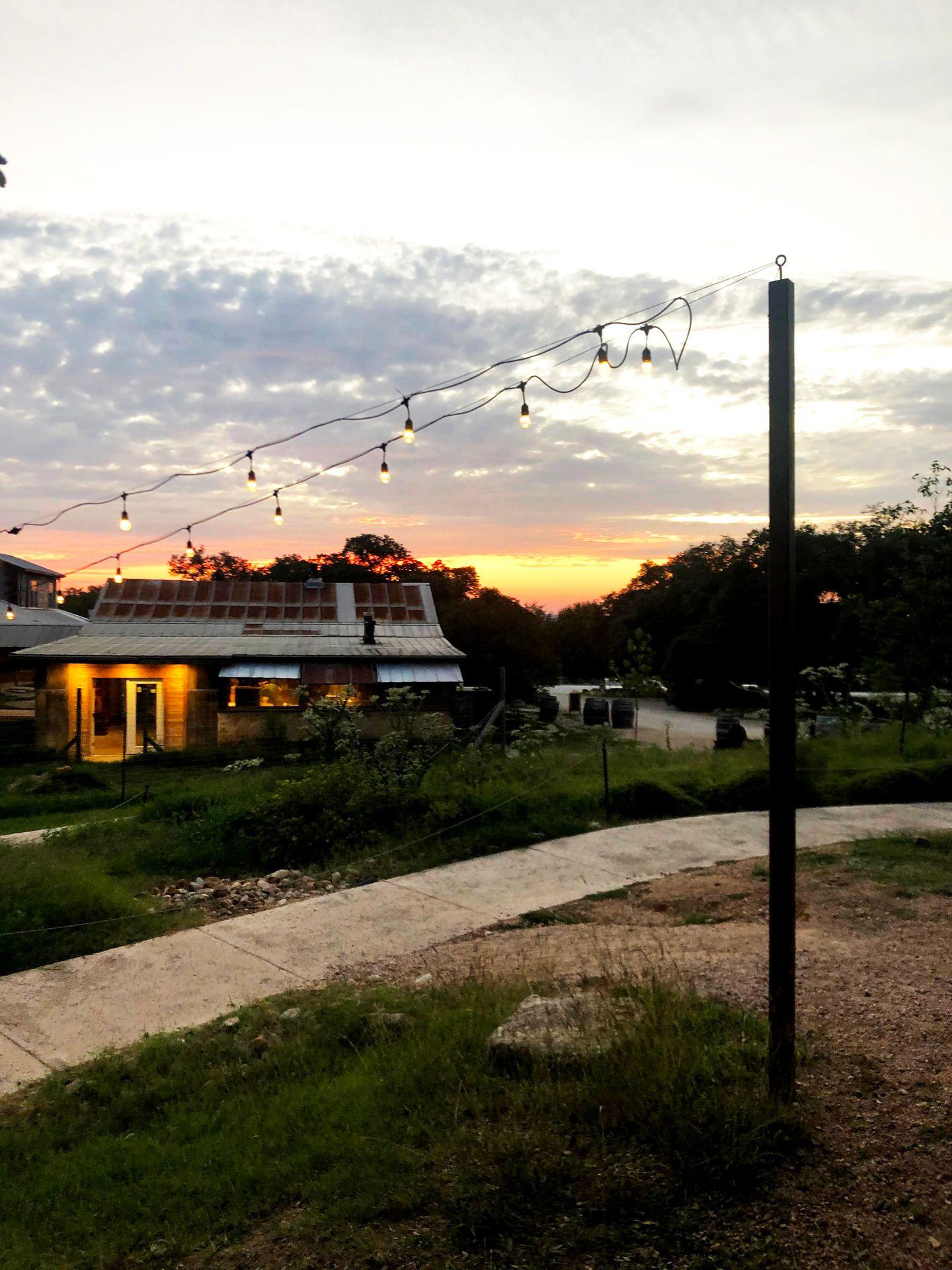 A view of the outside of Jester King Brewery during sunset.