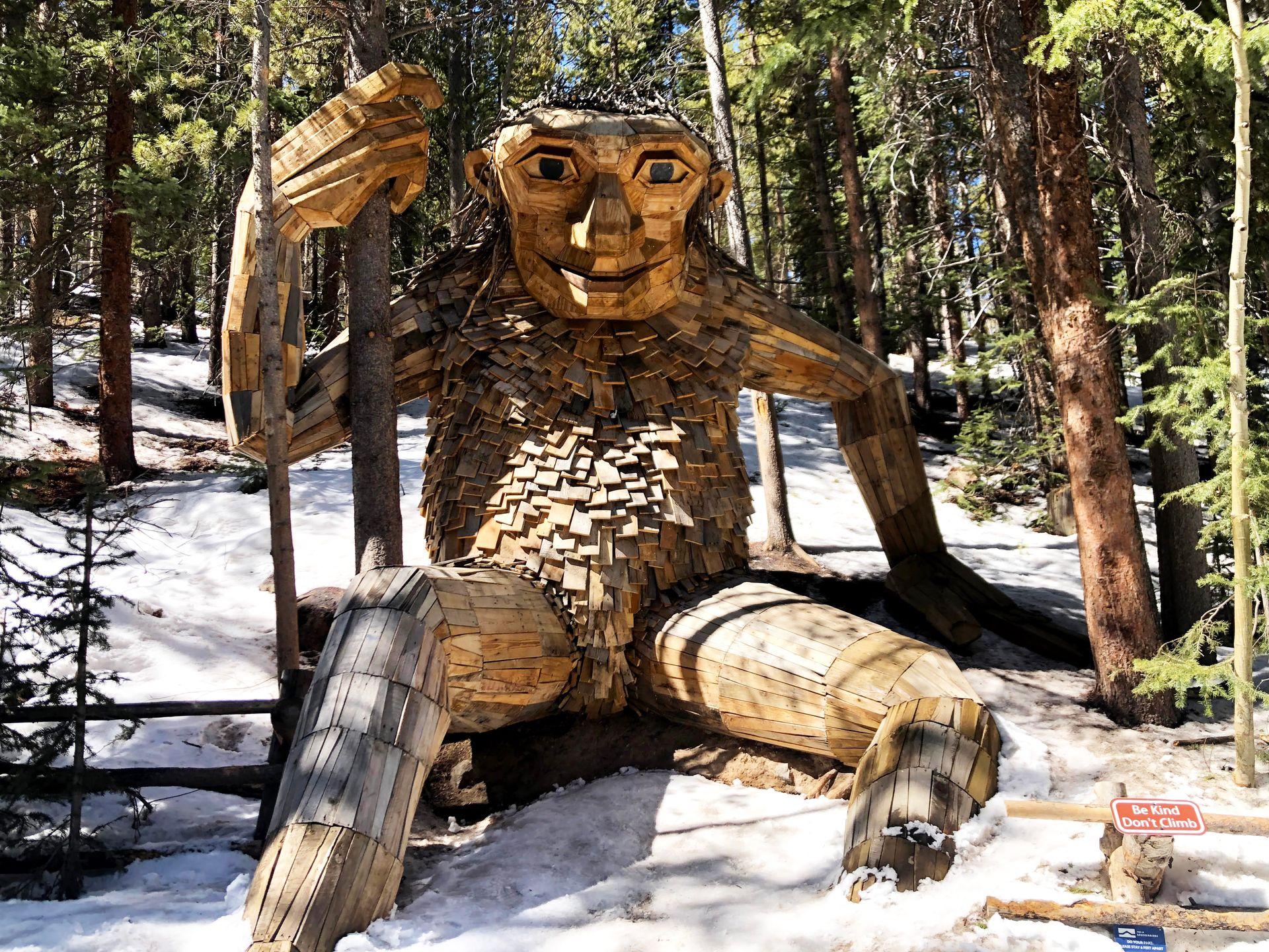 The Breckenridge Troll, a giant creature made out of wood that holds onto a tree.