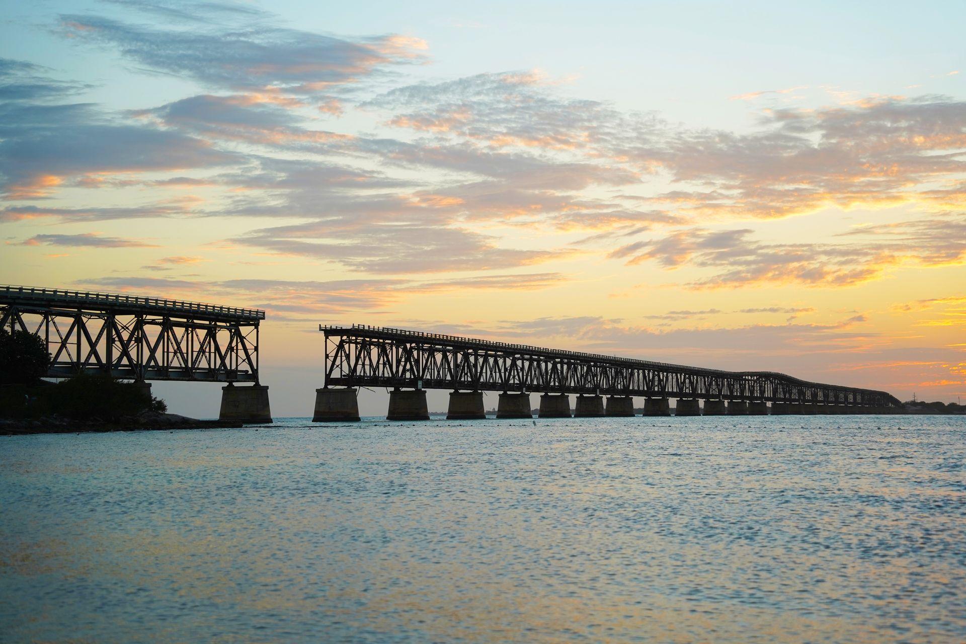 The sunset over the old Bahia Honda train bridge with the ocean in the foreground