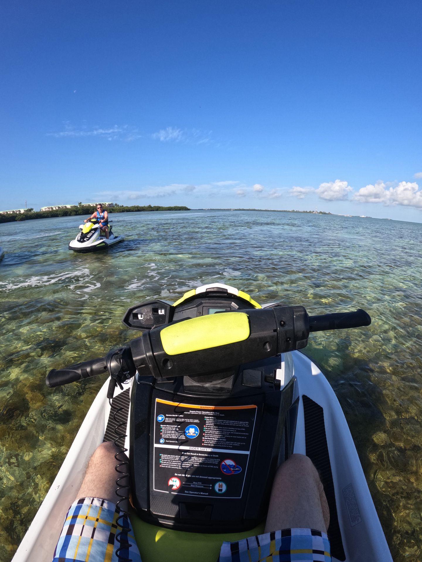 Looking out at the front of a jetski with the ocean in the background.