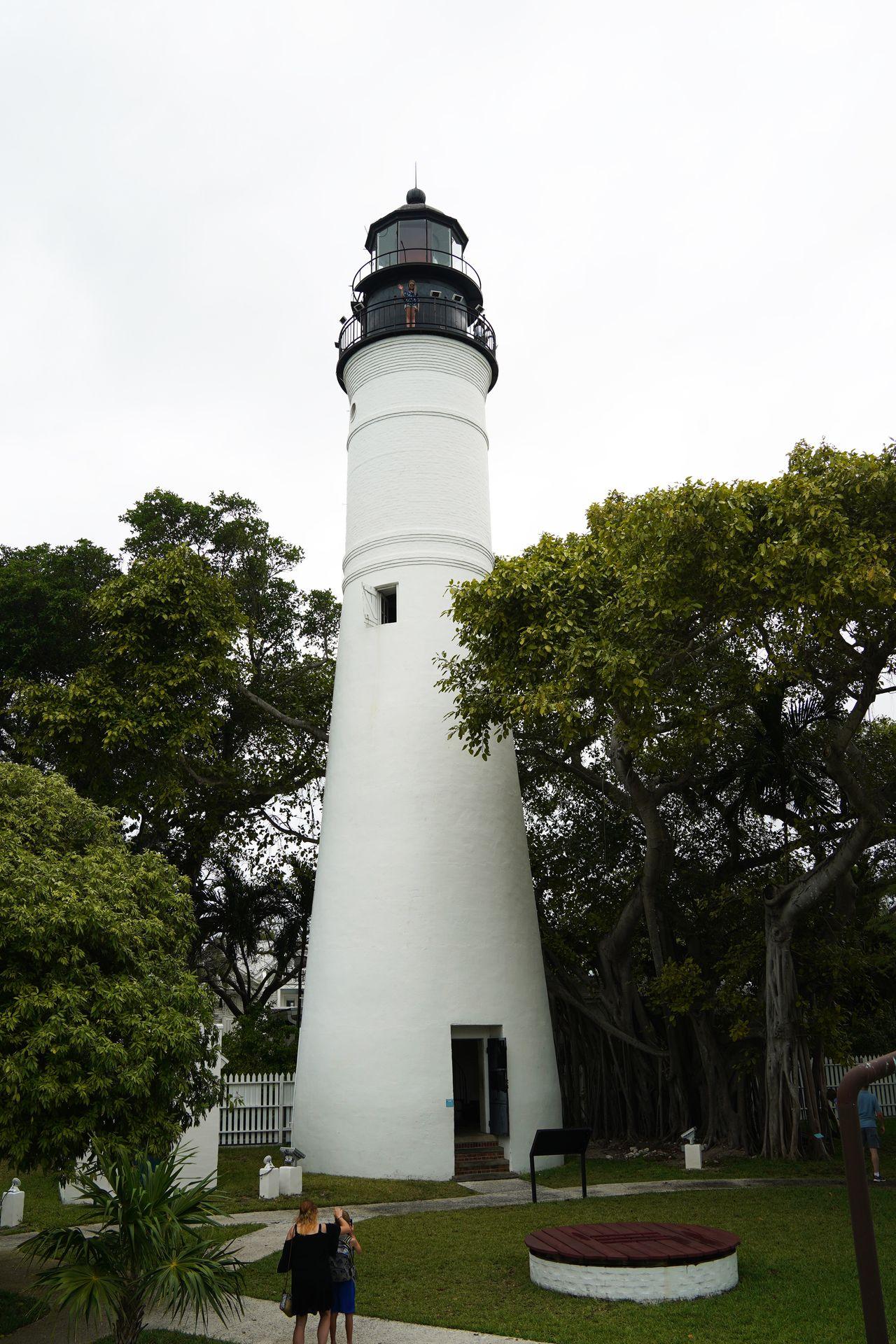 A white lighthouse surrounded by trees