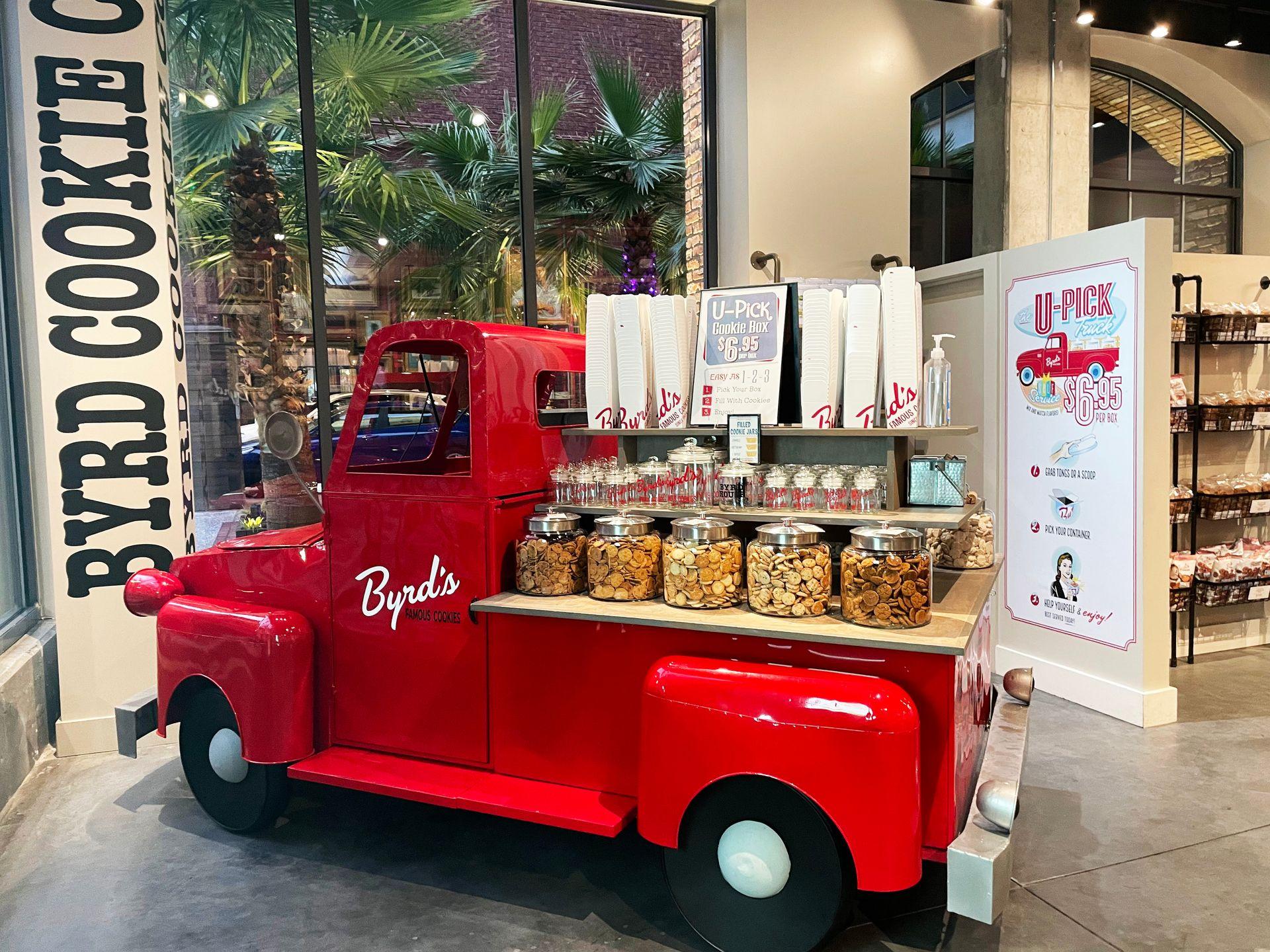 A red pick up truck with jars of cookies on top at Byrd's cookies in Savannah