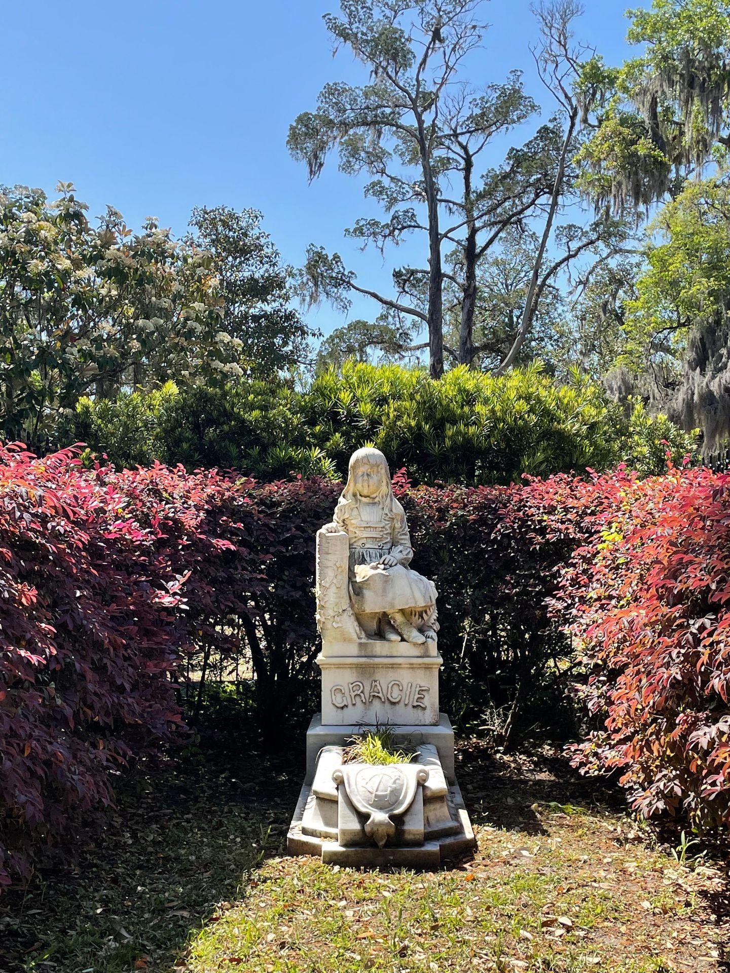 A white statue with a little girl sitting on the Bonaventure Cemetery