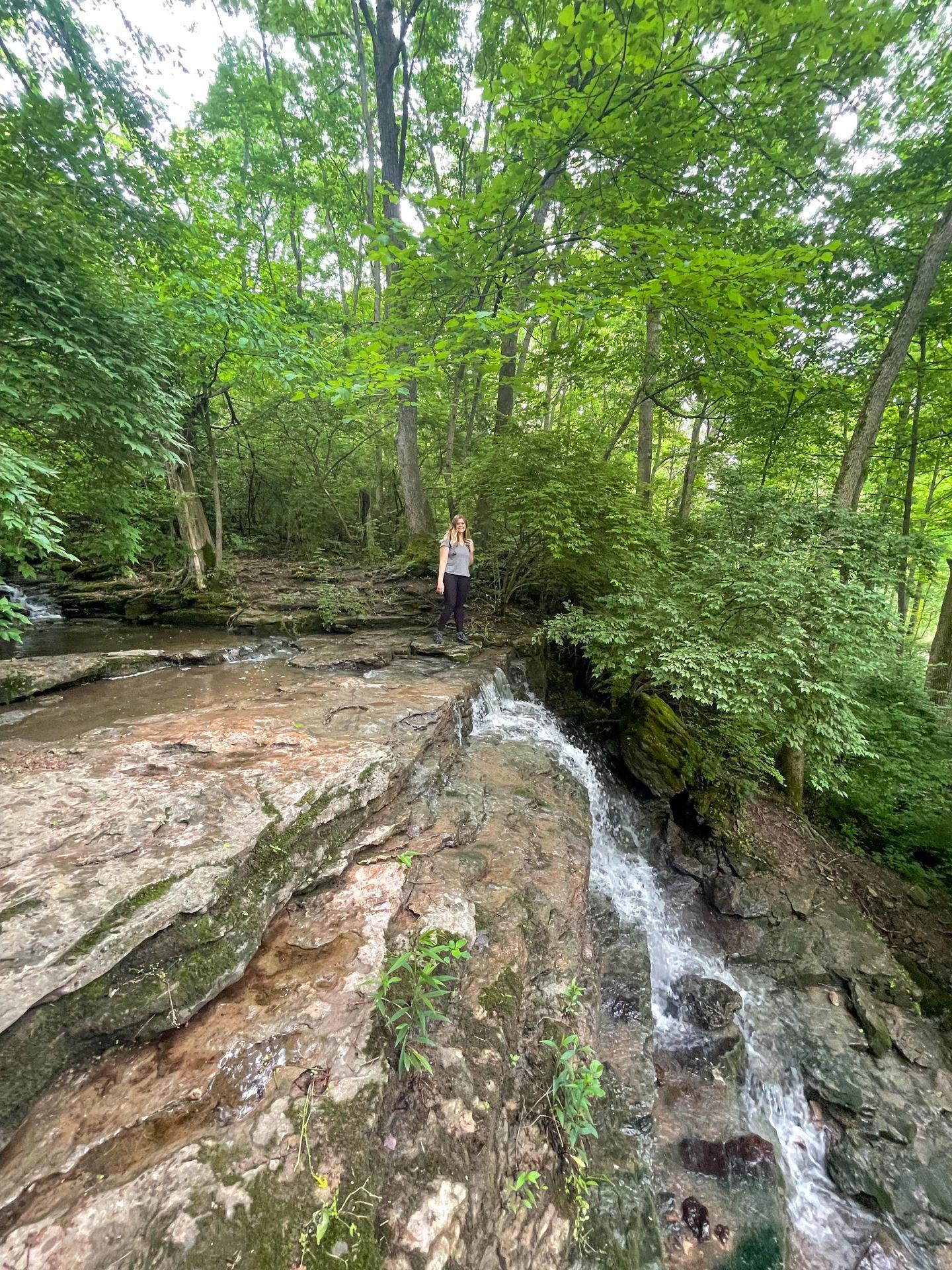 Lydia standing at the top of a waterfall in John Bryan State Park