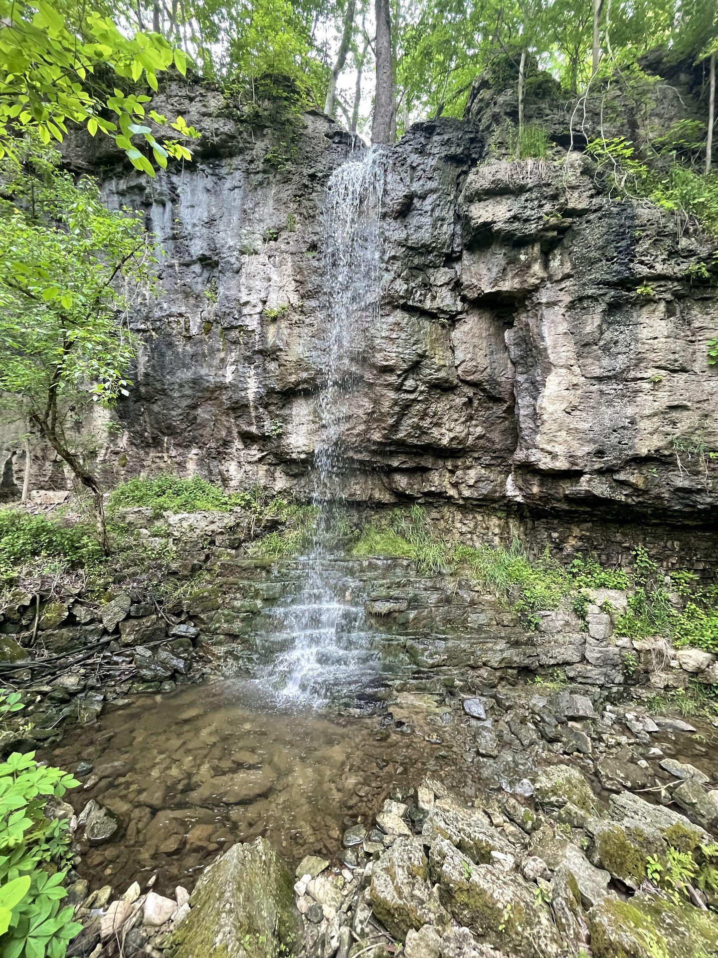 A narrow waterfall falling down a flat rock face in Clifton Gorge State Nature Preserve