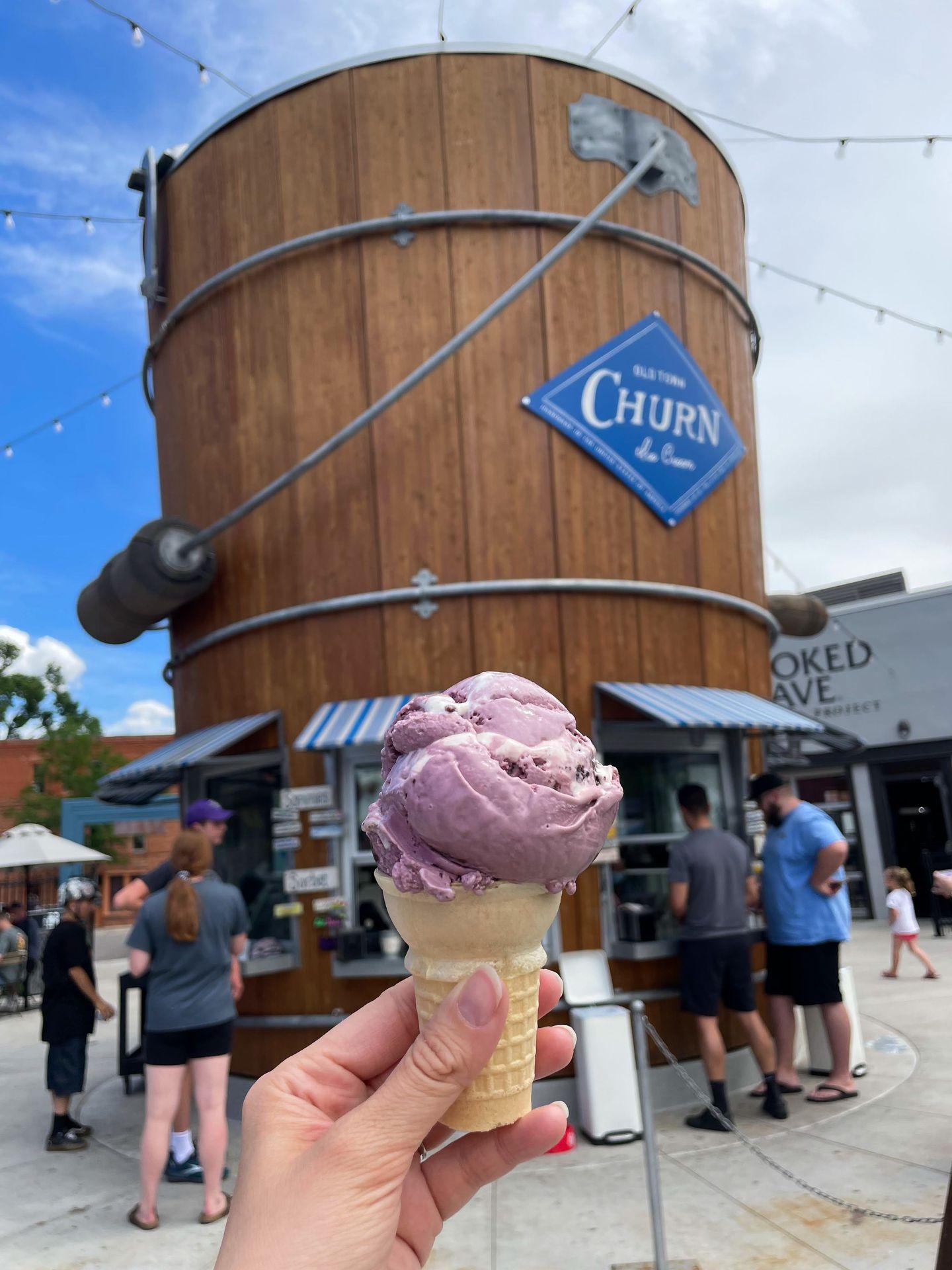 Holding up an ice cream cone with purple ice cream from Old Churn Ice Cream in Fort Collins.