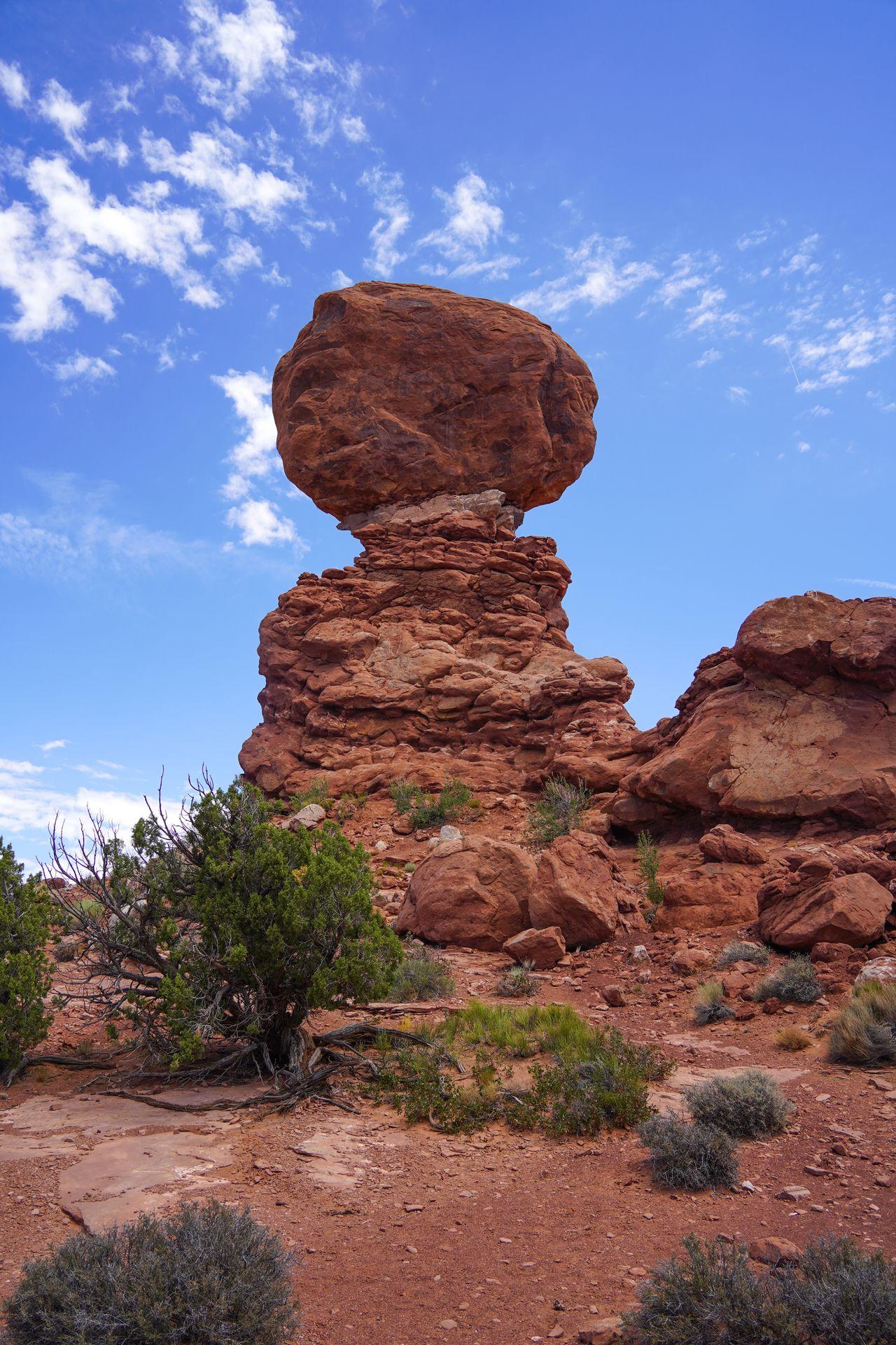 The balanced rock in Arches National Park. There is a giant boulder that looks to balance on a narrow point.