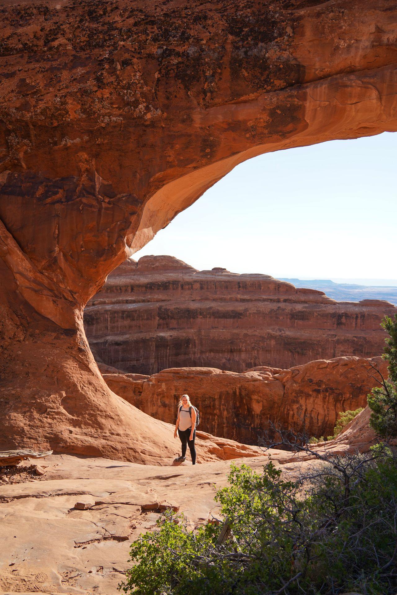 Lydia standing below the large Partition Arch on the Devil's Garden trail.