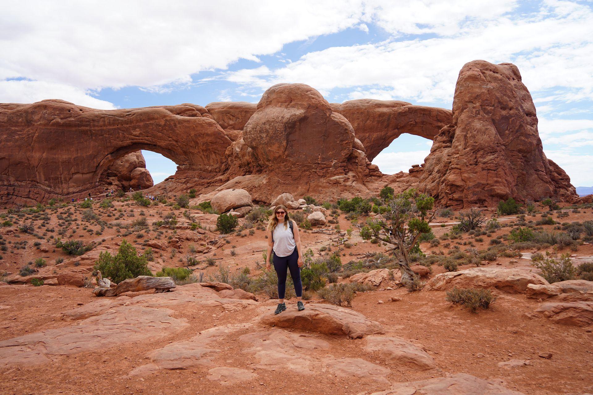 Lydia standing in front of the window arches on the Window Arch trail.