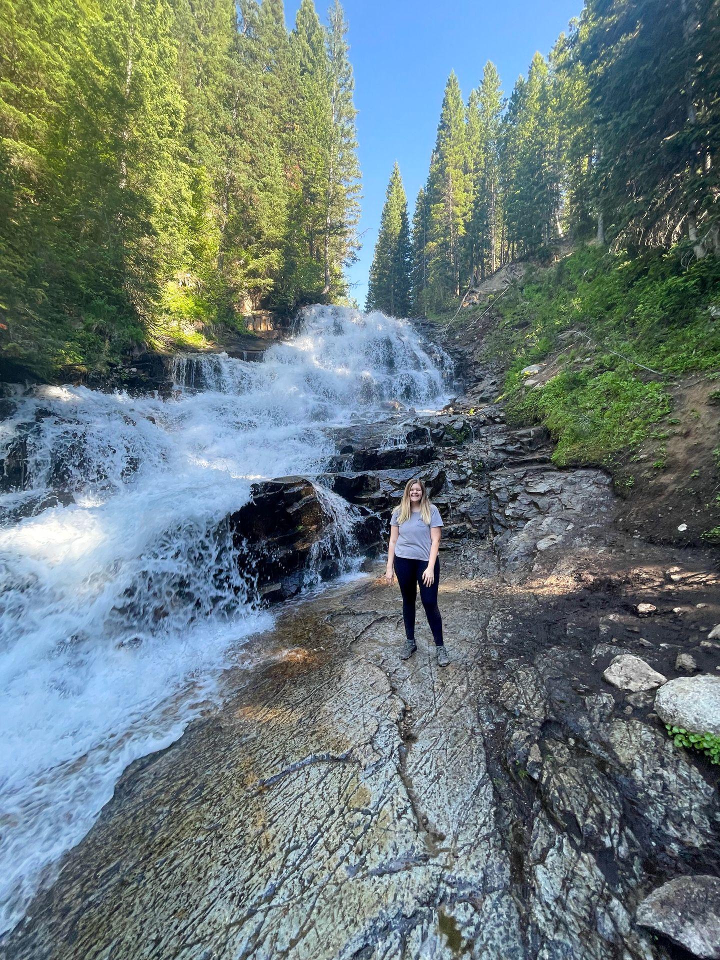 Lydia standing in front of Gloria Falls.