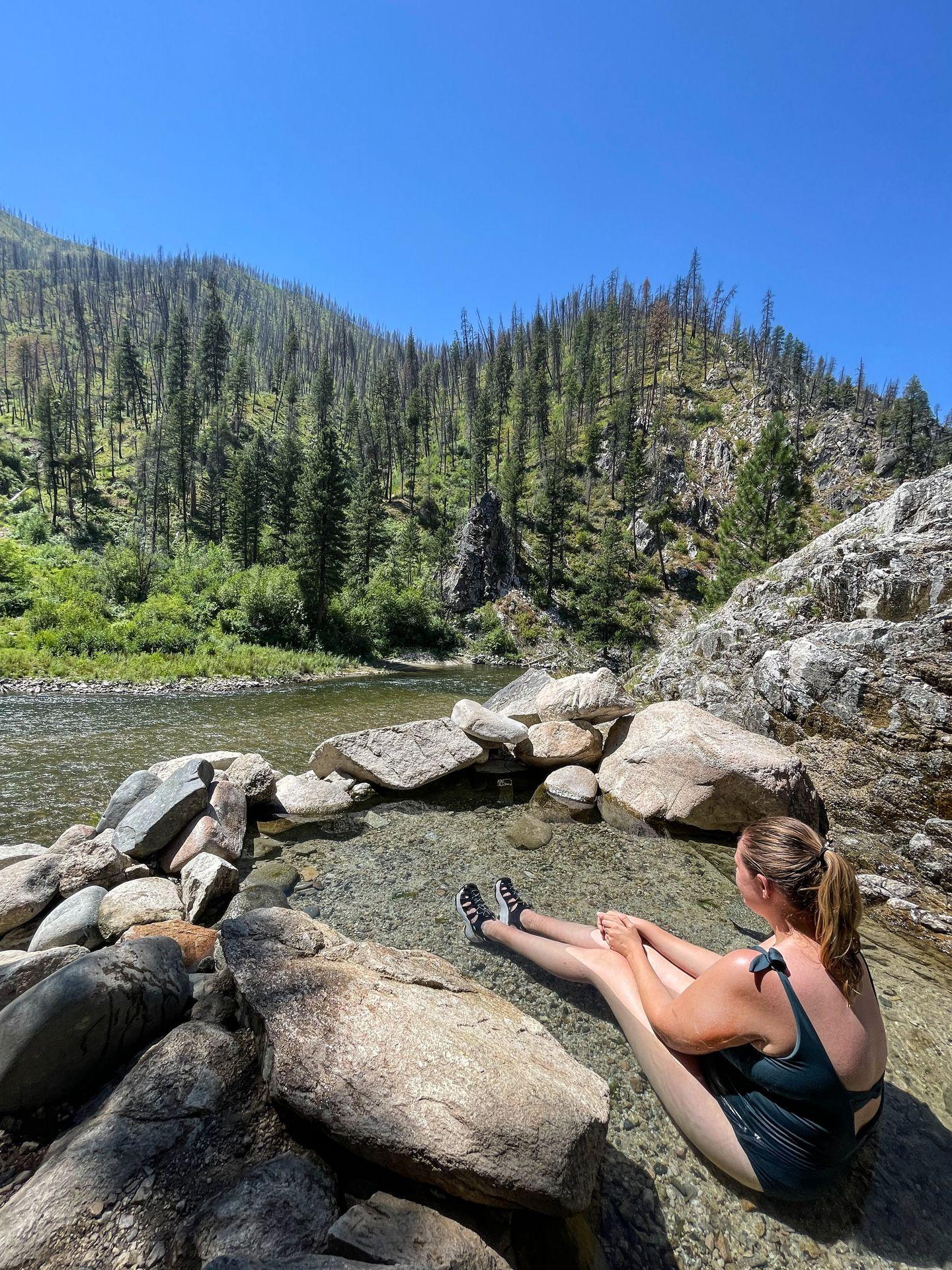 Lydia sitting at Pine Flat Hot Springs looking out at the Payette River.
