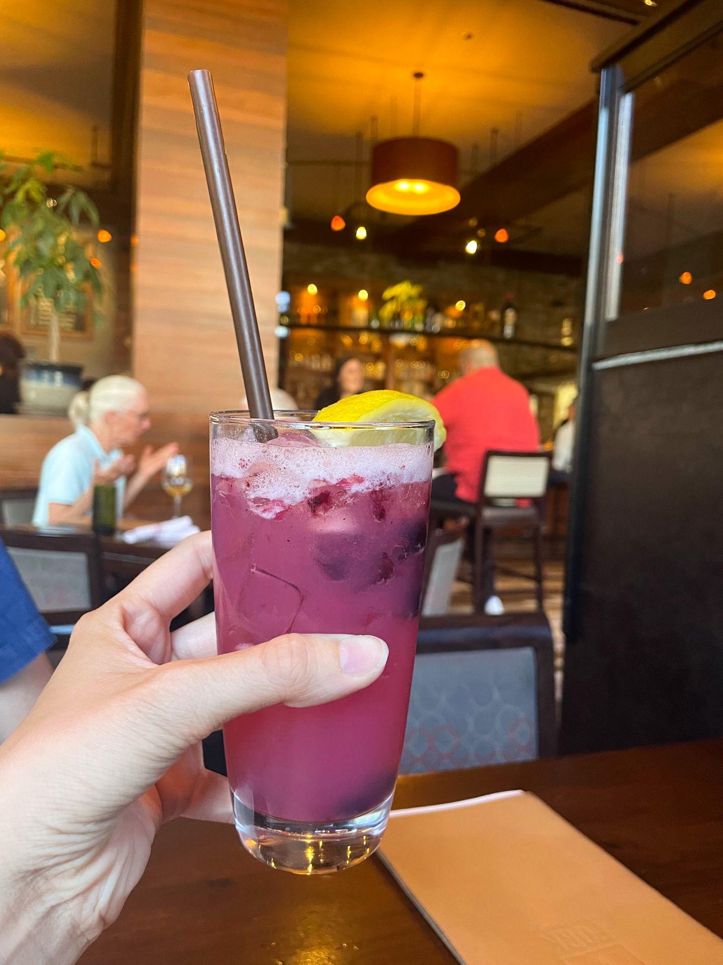 Holding up a purple cocktail from Fork in downtown Boise.