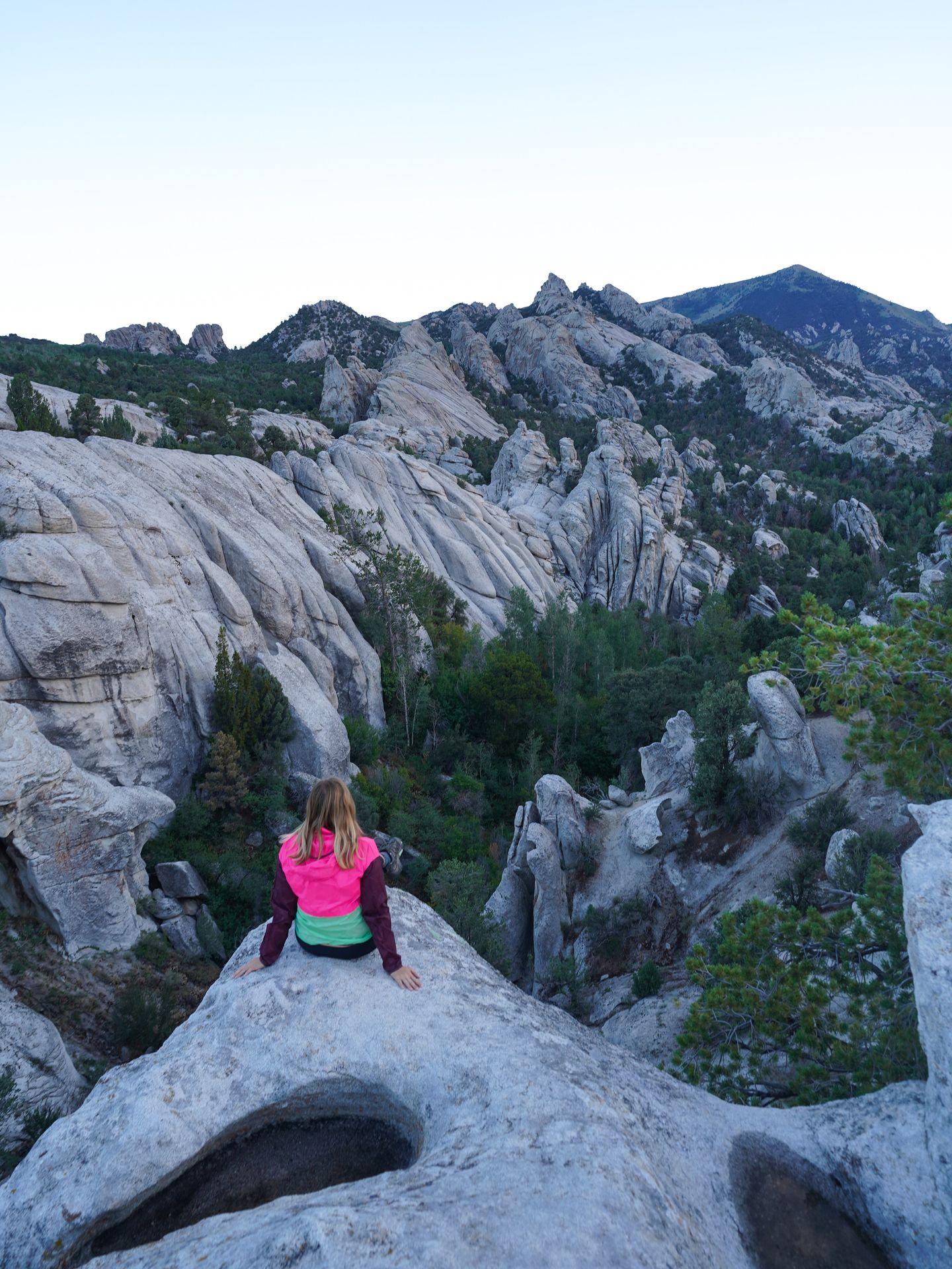 Lydia gazing out at white rock formations from her campsite in City of Rocks