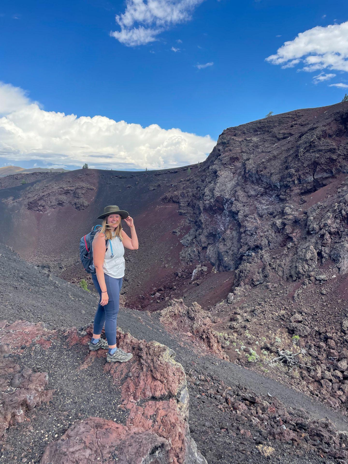 Lydia standing in an area of red and black rocks at Craters of the Moon National Monument.