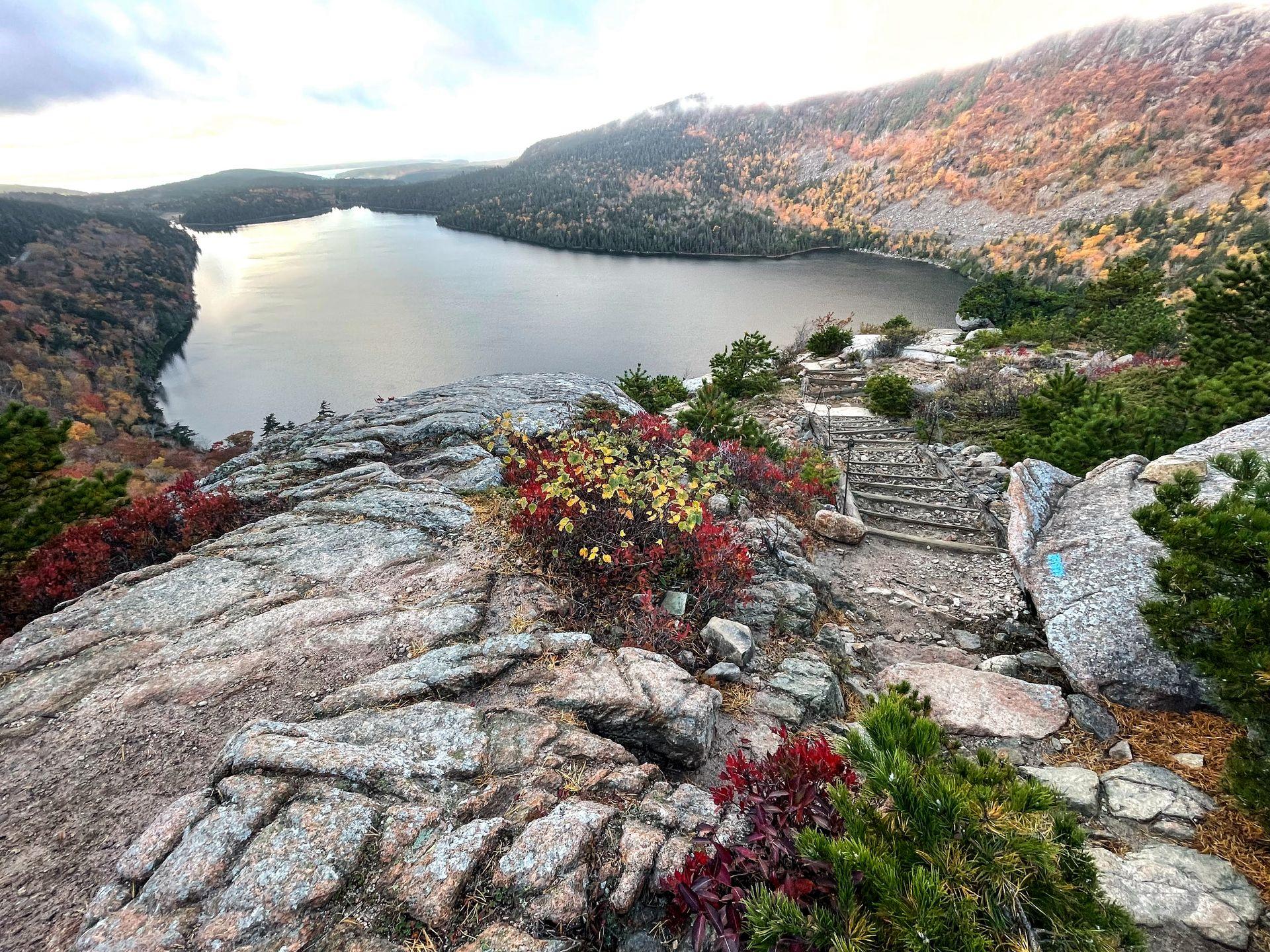Looking down at Jordan Pond from the top of the South Bubble. The surrounding mountains are covered in fall colors.