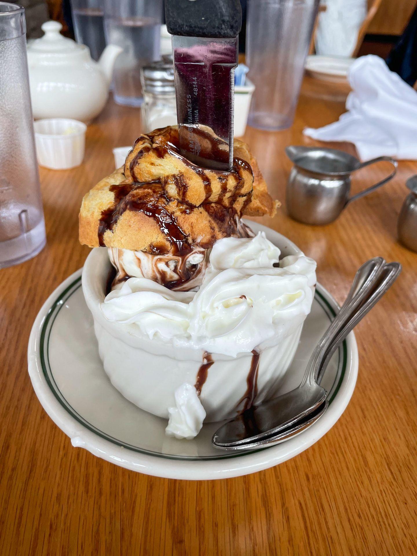 An ice cream sundae inside of a popover that has been cut open.