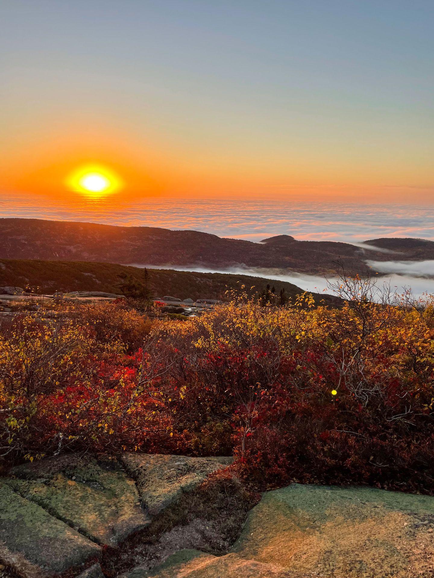The sun rising above a cloud inversion from Cadillac Mountain.