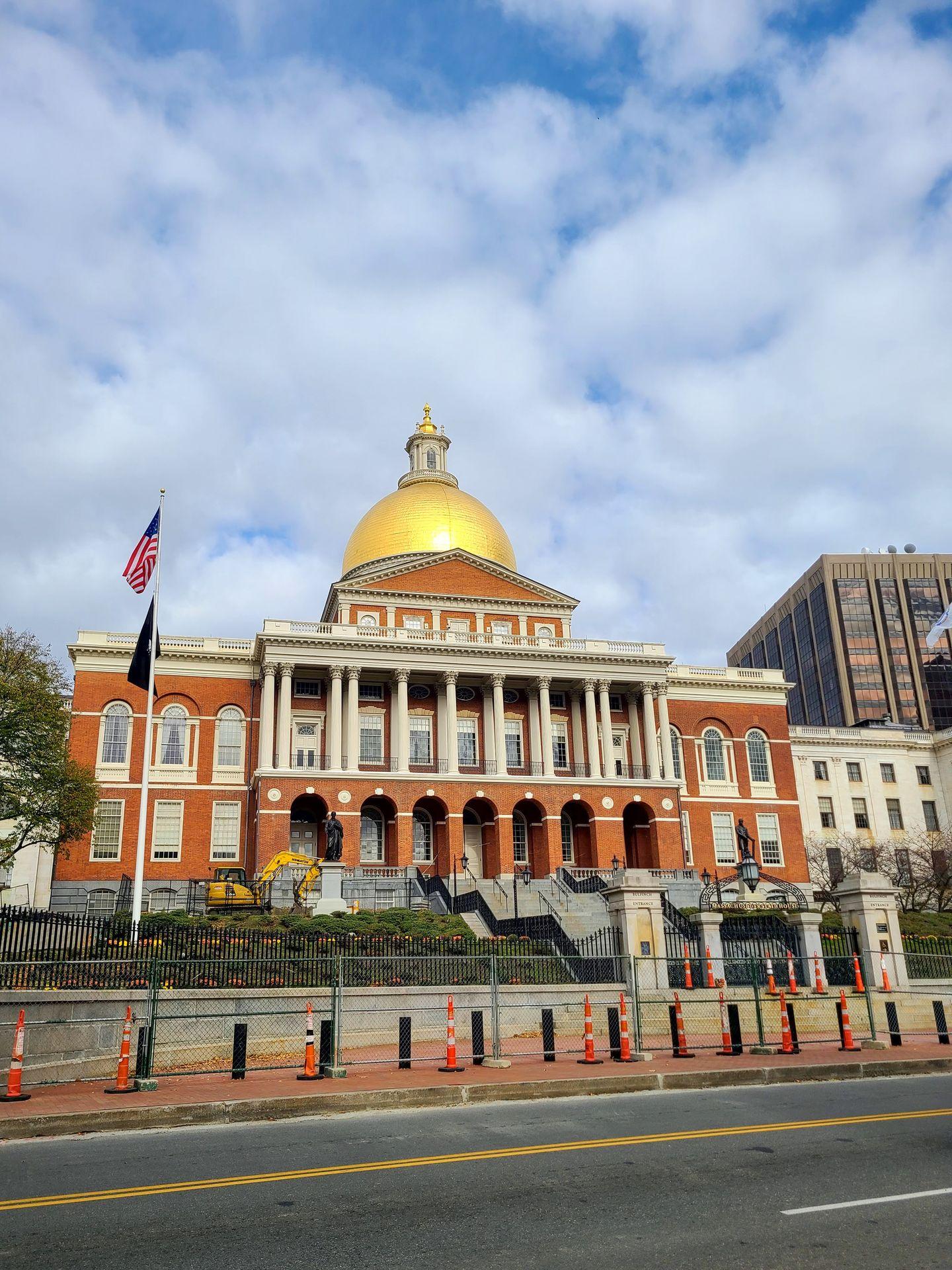 A view of the Massachusetts State House from across the street. The dome at the top is made of gold.