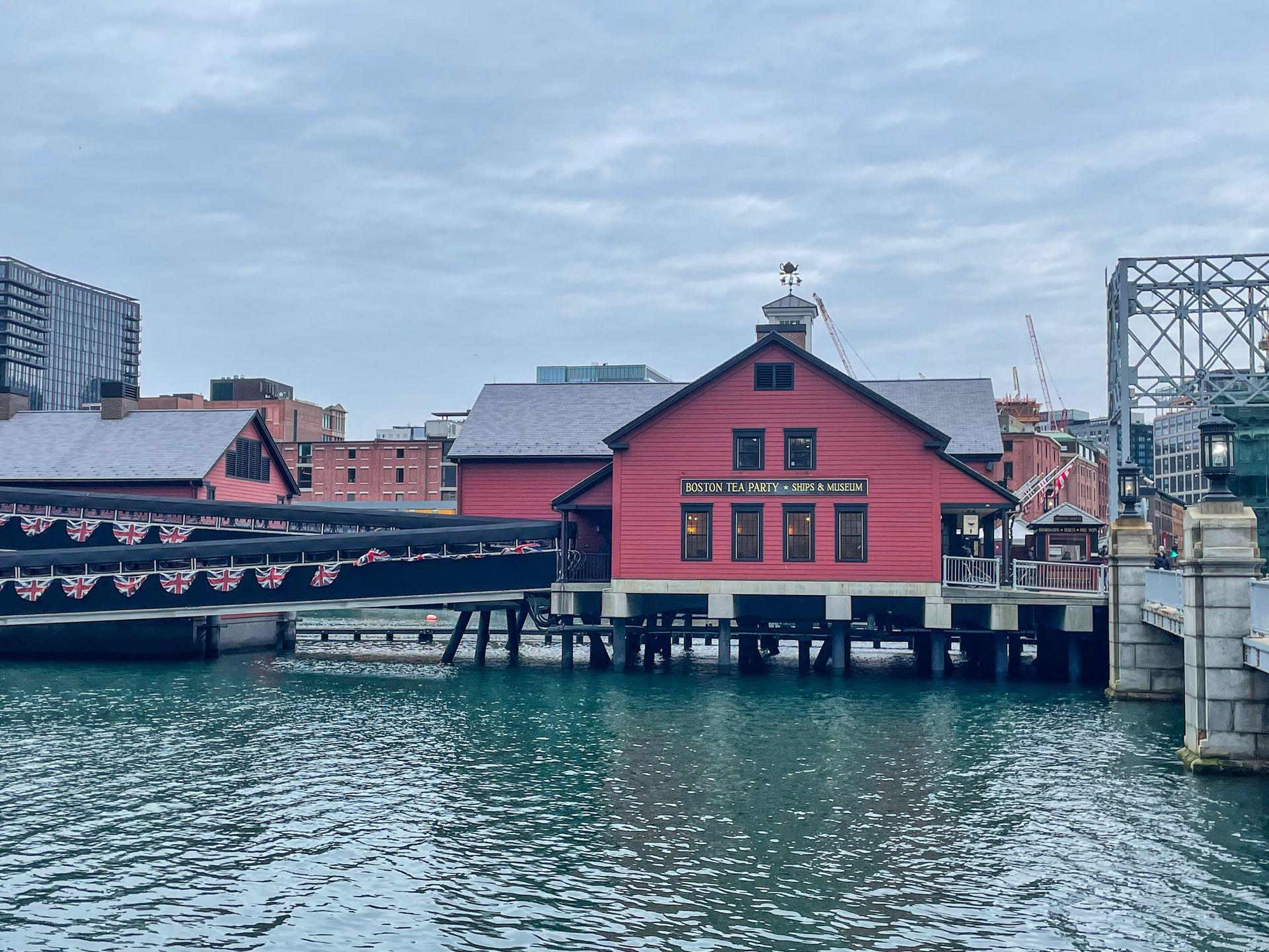 The exterior of the Boston Tea Party Museum, a red building over the water.