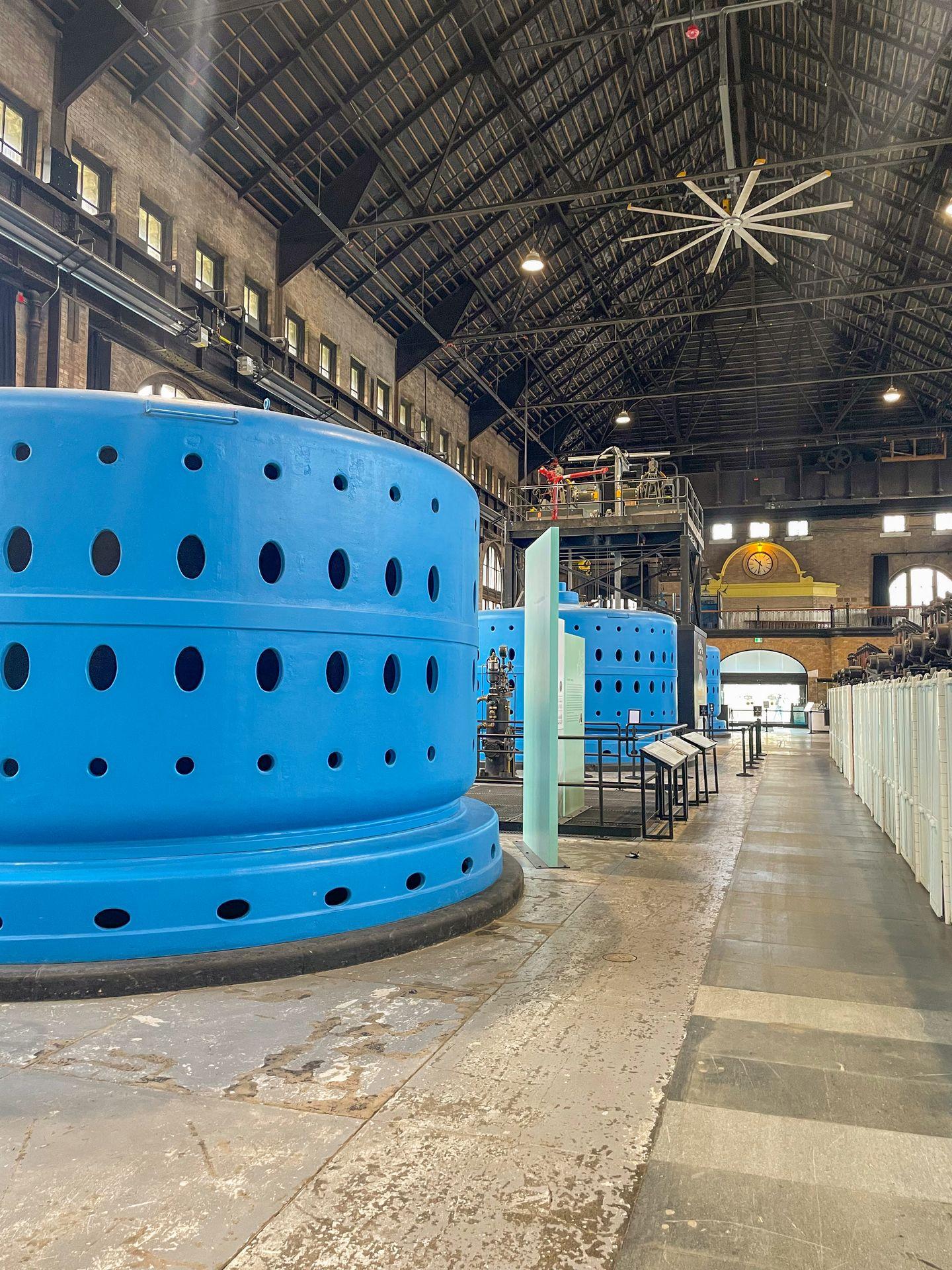 A warehouse with large, light blue pieces of machinery