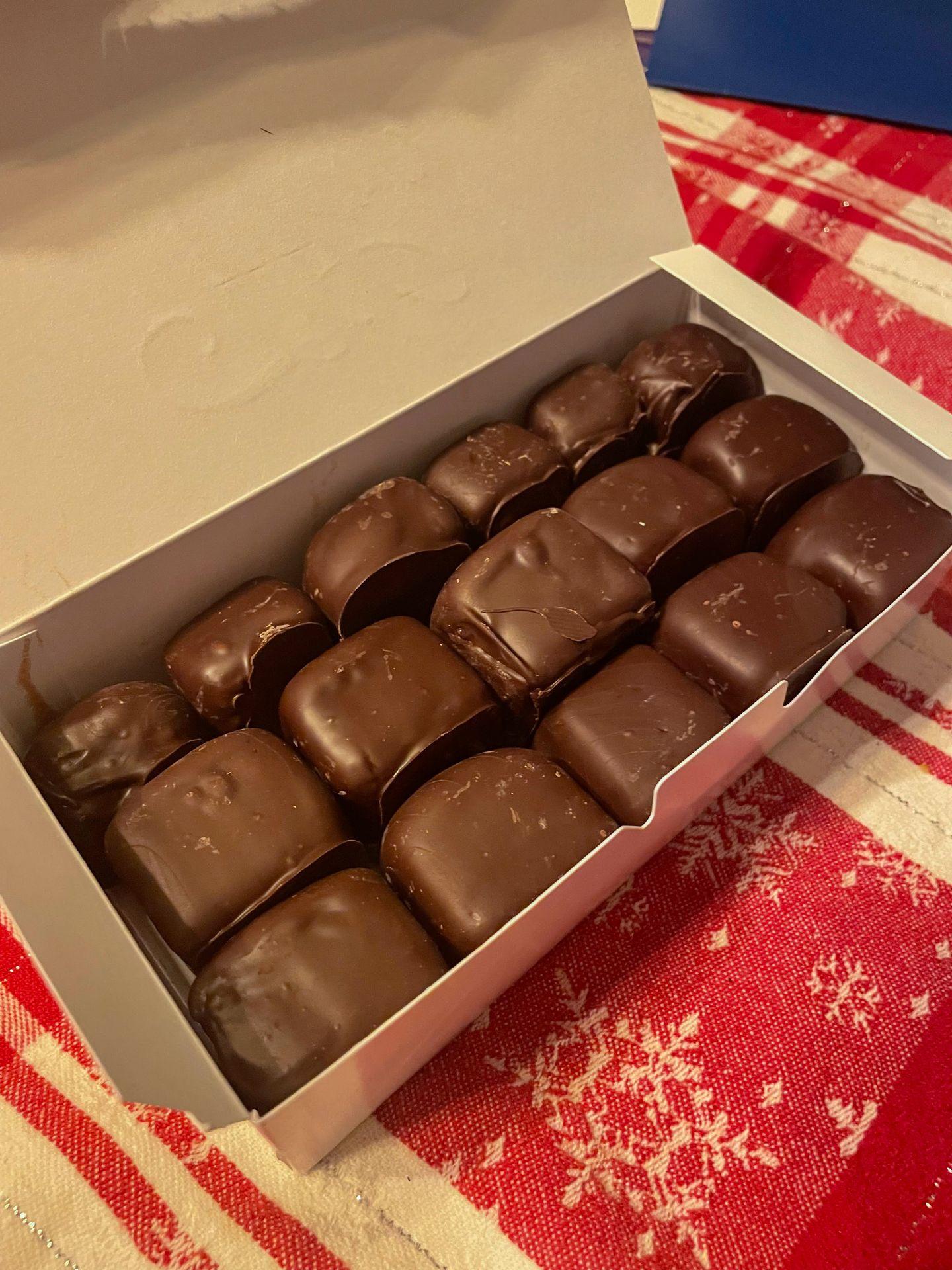 A box full of several pieces of buffalo sponge candy. They look like chocolate squares with rounded edges.