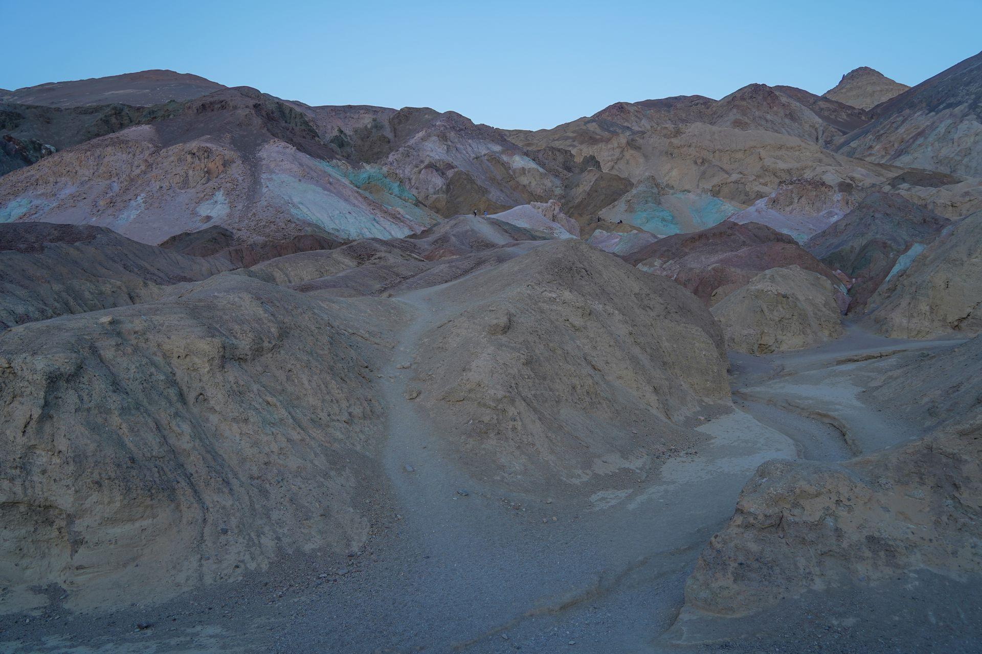 A series of rocks where some glow blue, green and pink at Artist's Palette in Death Valley.