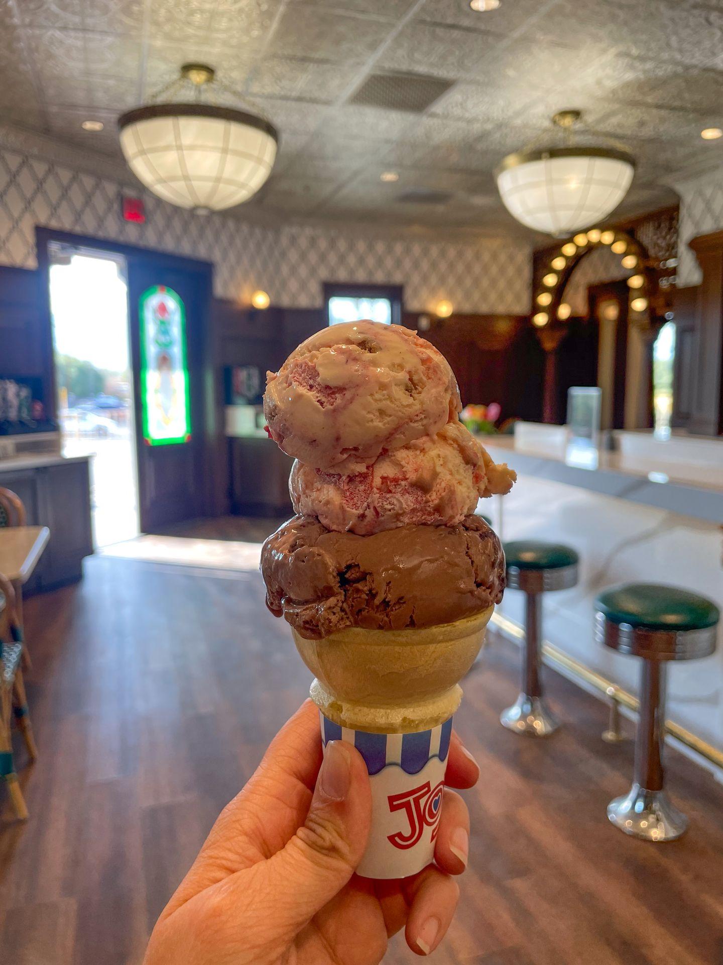 A cone with two scoops of ice cream: chocolate and strawberry. It's being held up inside the Ice Cream Parlor at Death Valley.