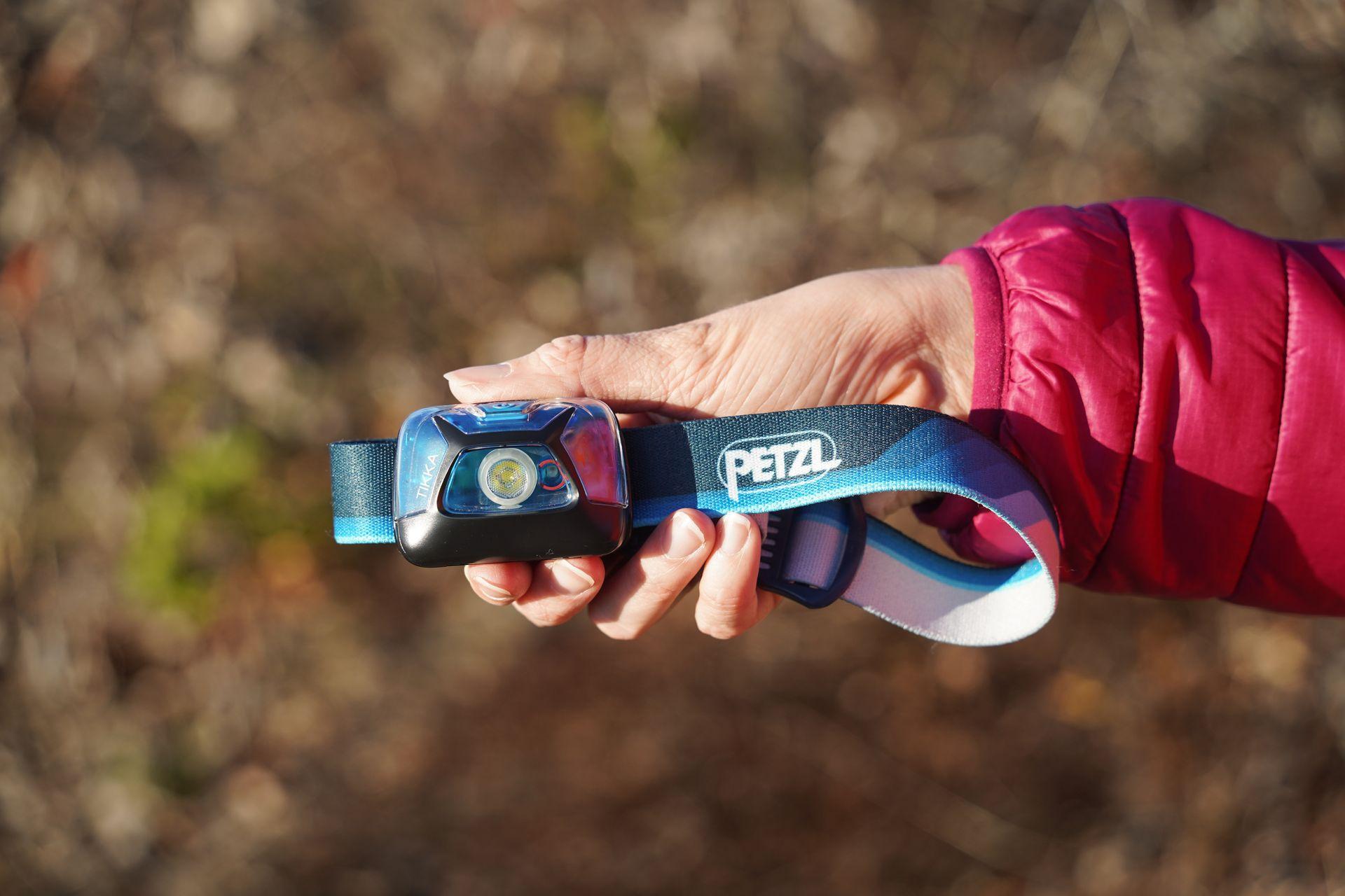 Holding up a Petzl head lamp.