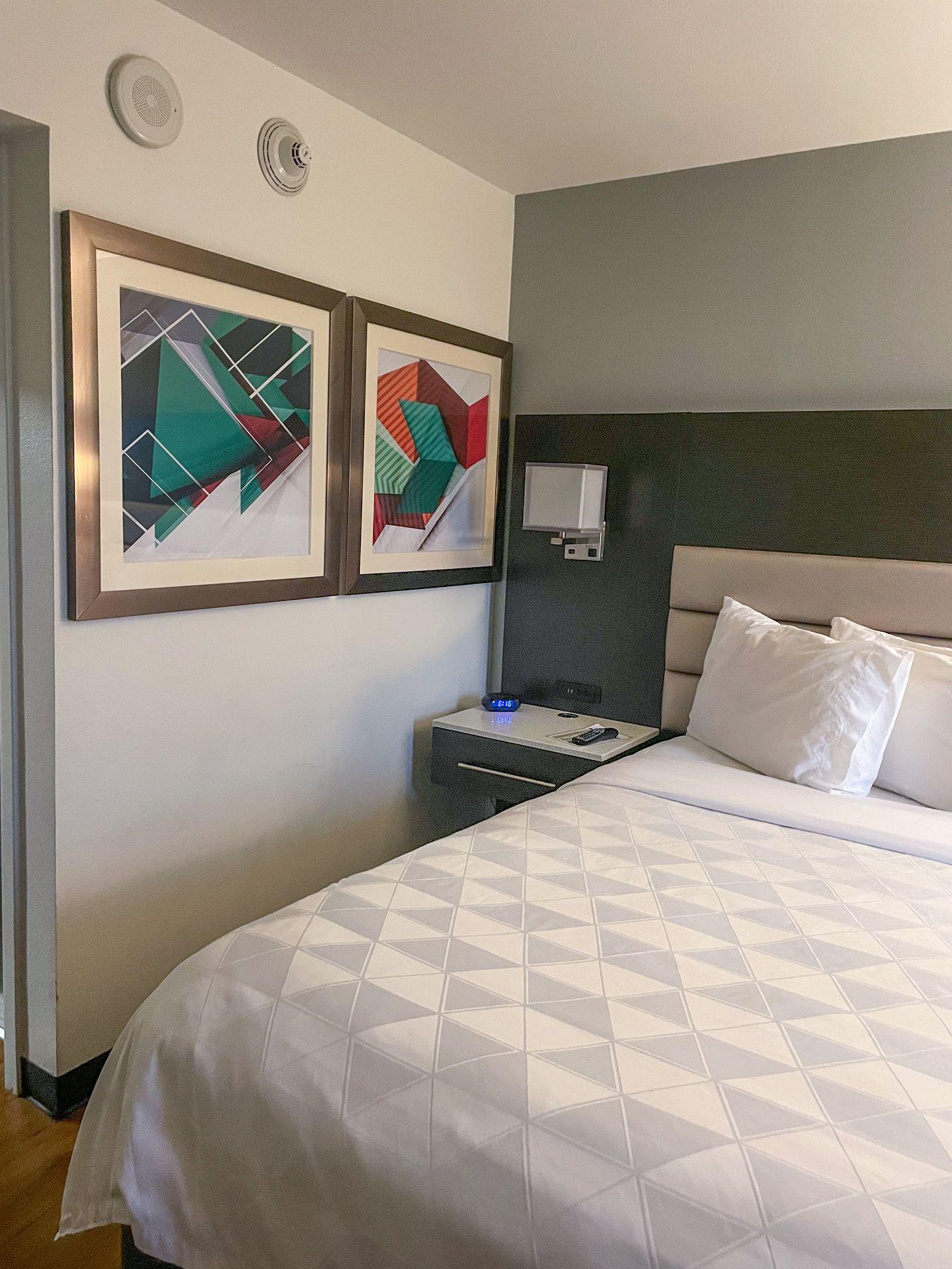A bed with artwork on the wall next to it inside Holiday Inn Beaumont Plaza