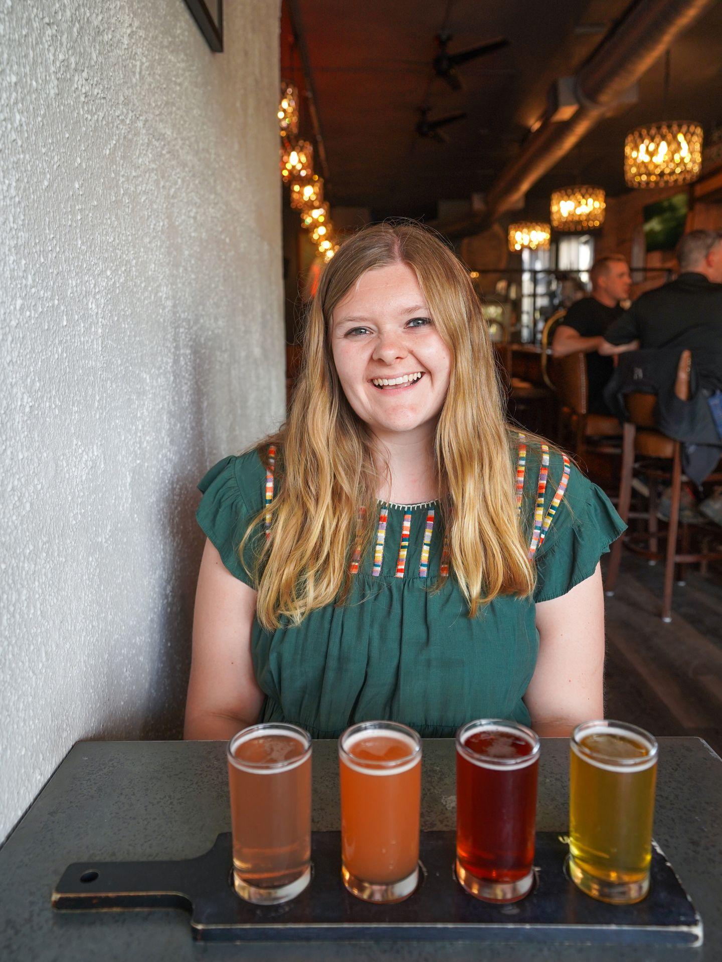 Lydia sitting behind a flight of beer at One Barrel Brewing.