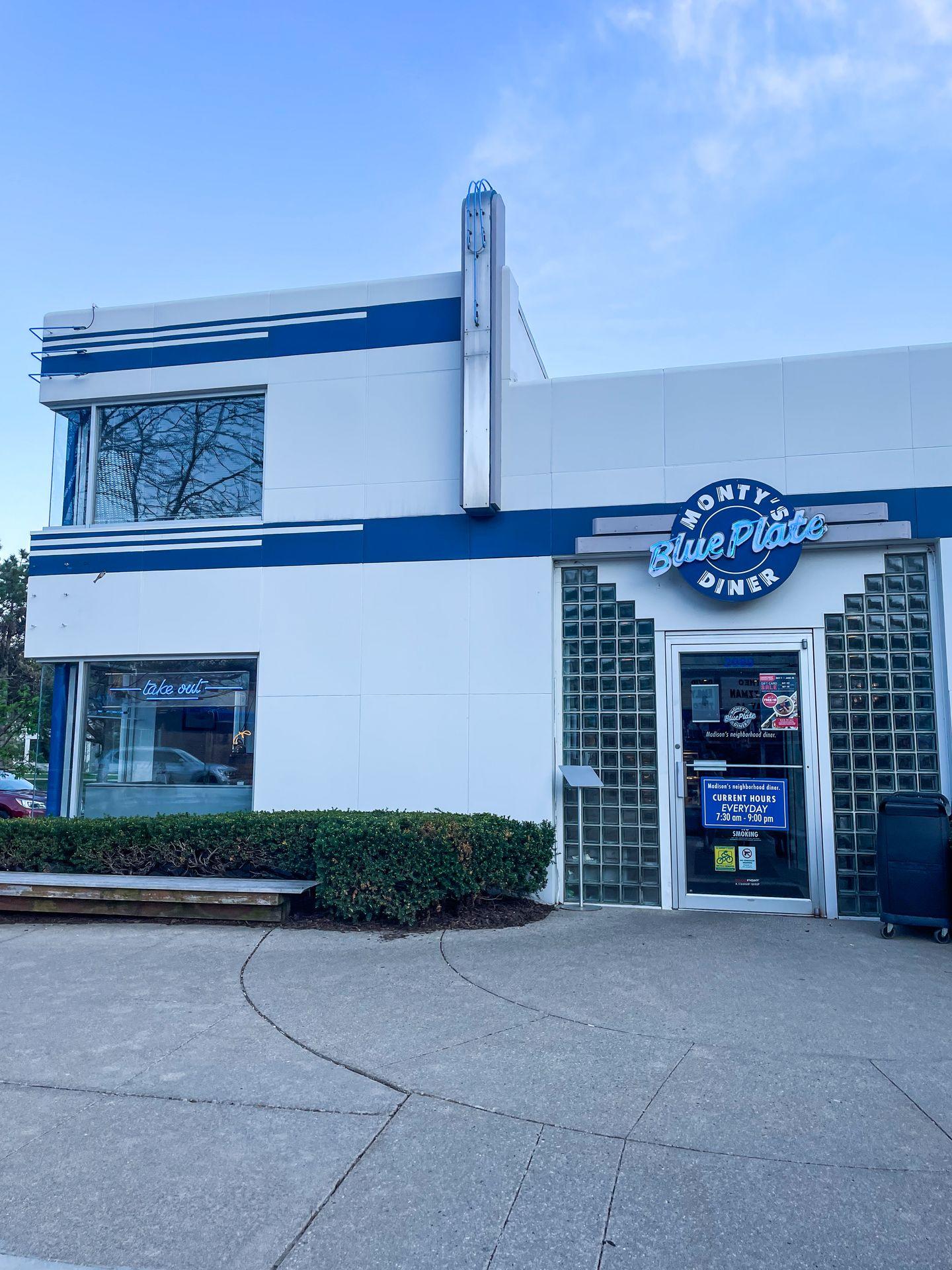 The exterior of Monty's Blue Plate Diner. The building is white with blue lettering and looks very retro.