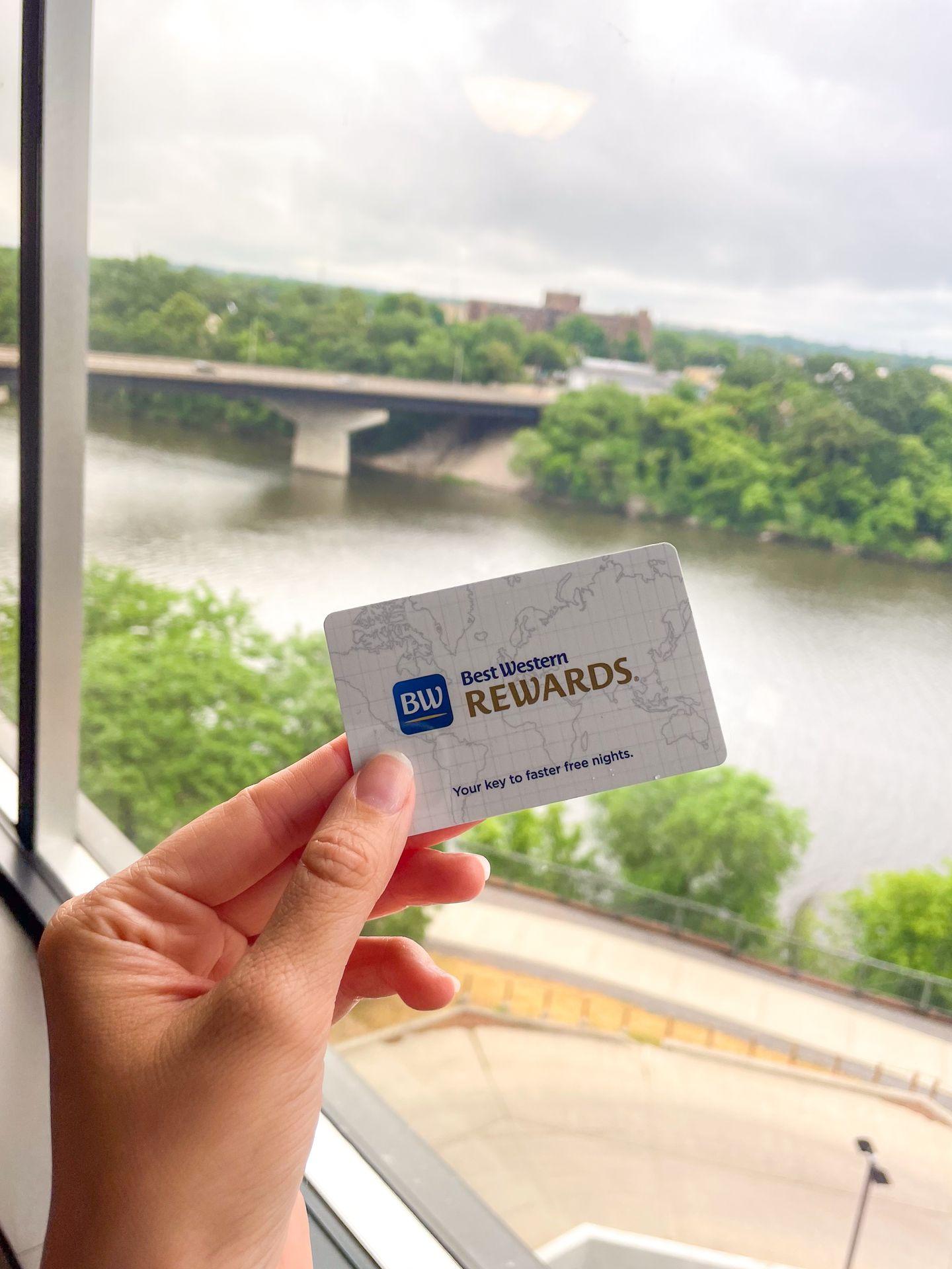A hand holding a Best Western room key overlooking the Mississippi River