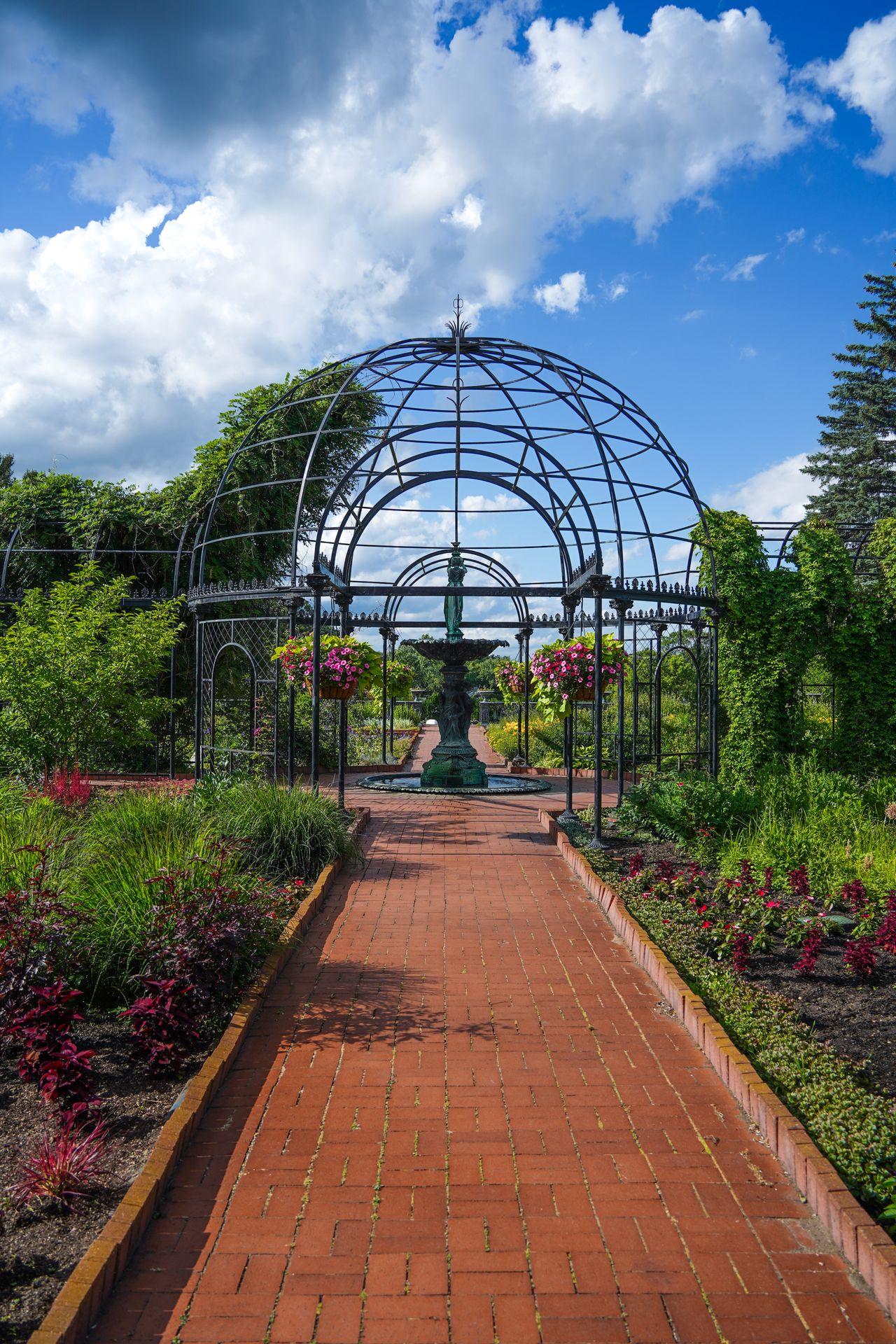 A structure and a fountain surrounded by flowers at Munsinger Gardens