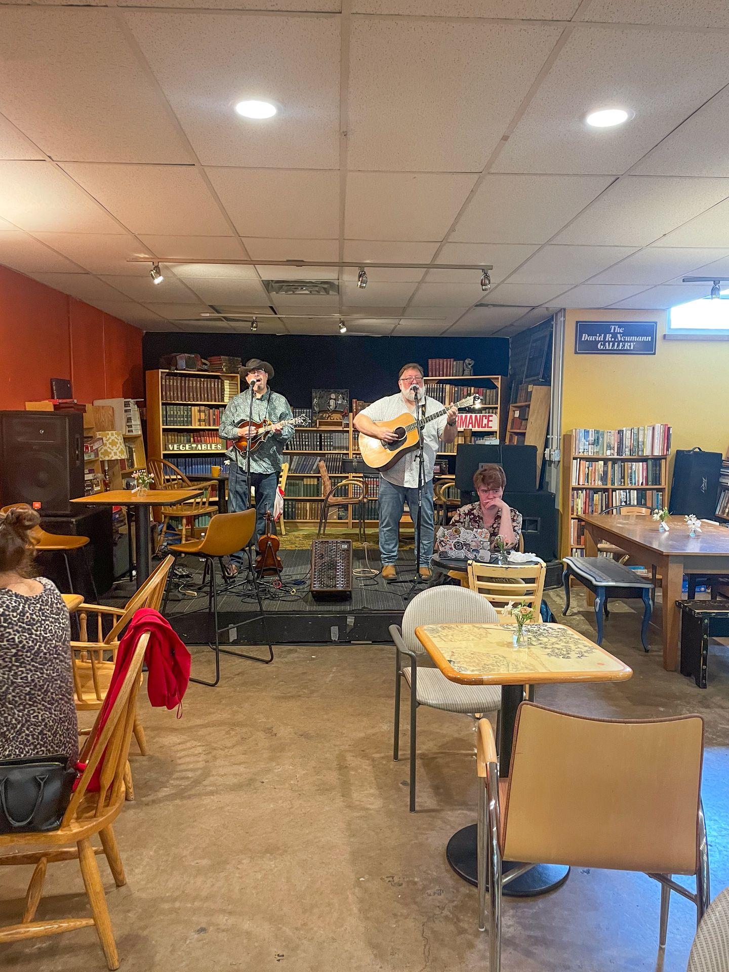 Two musicians performing on a stage at Webster’s Bookstore Cafe