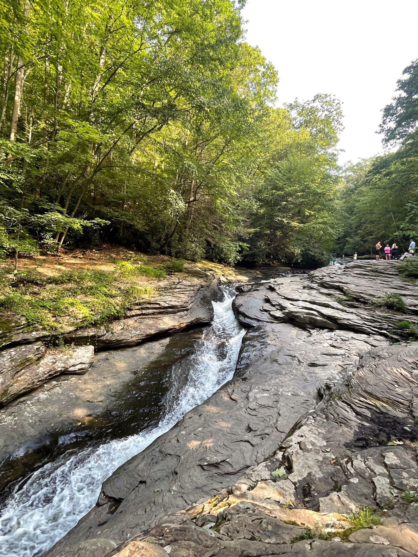 A narrow stream of water cascading through a rock face in Ohiopyle State Park.