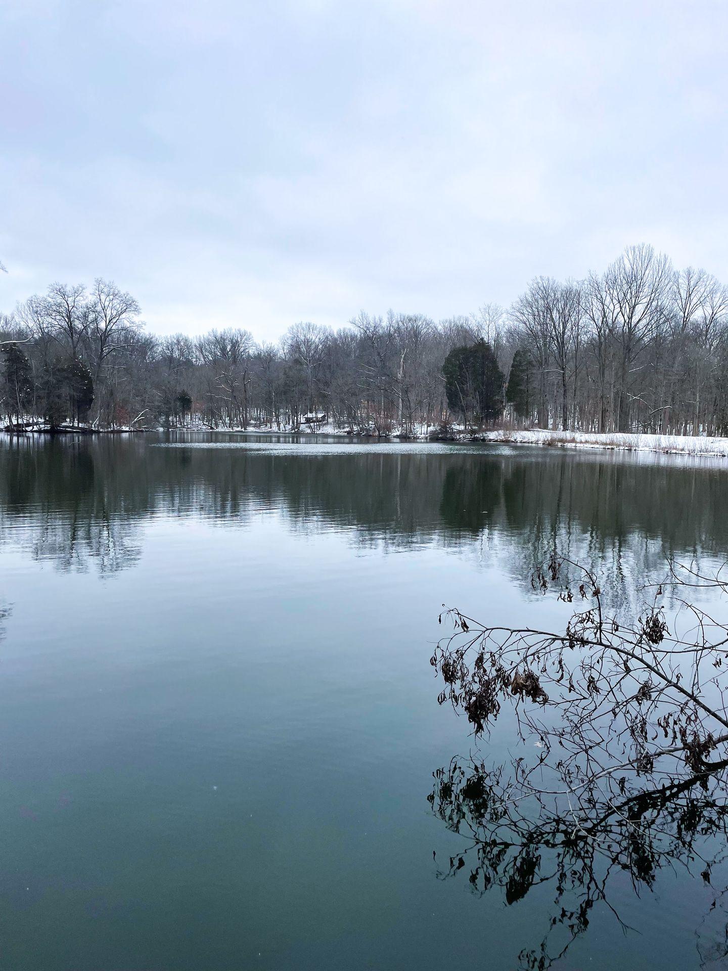 A lake next to a snowy shore at the Cincinnati Nature Center