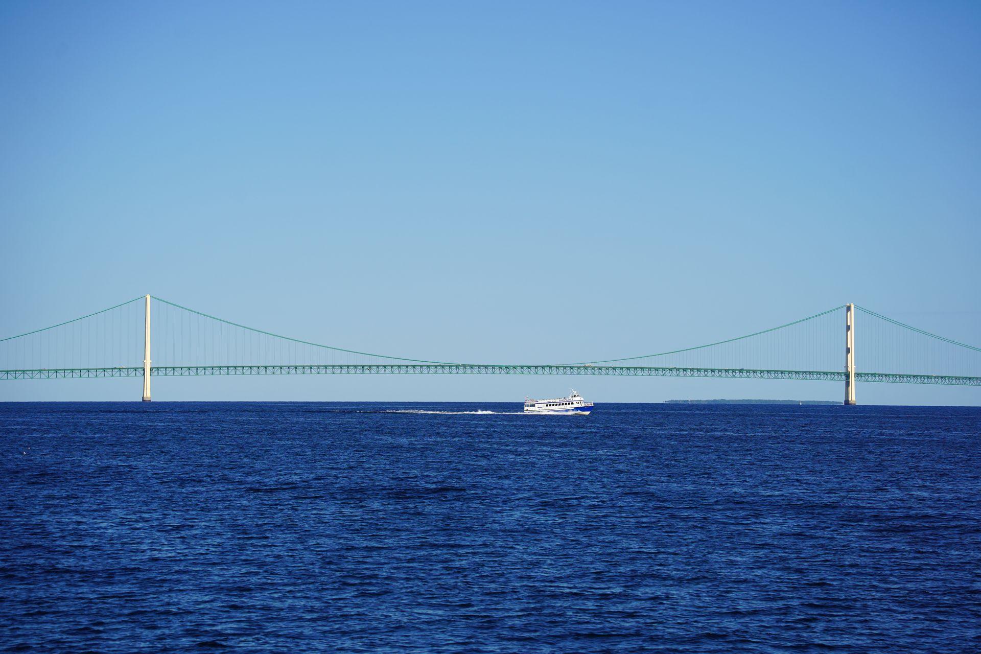 Looking in the distance at a ferry in front of Mackinac Bridge