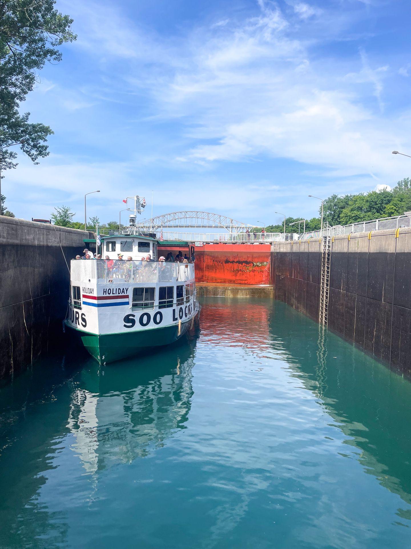 A boat that reads "Soo Lock" waits for the water to fill up the lock