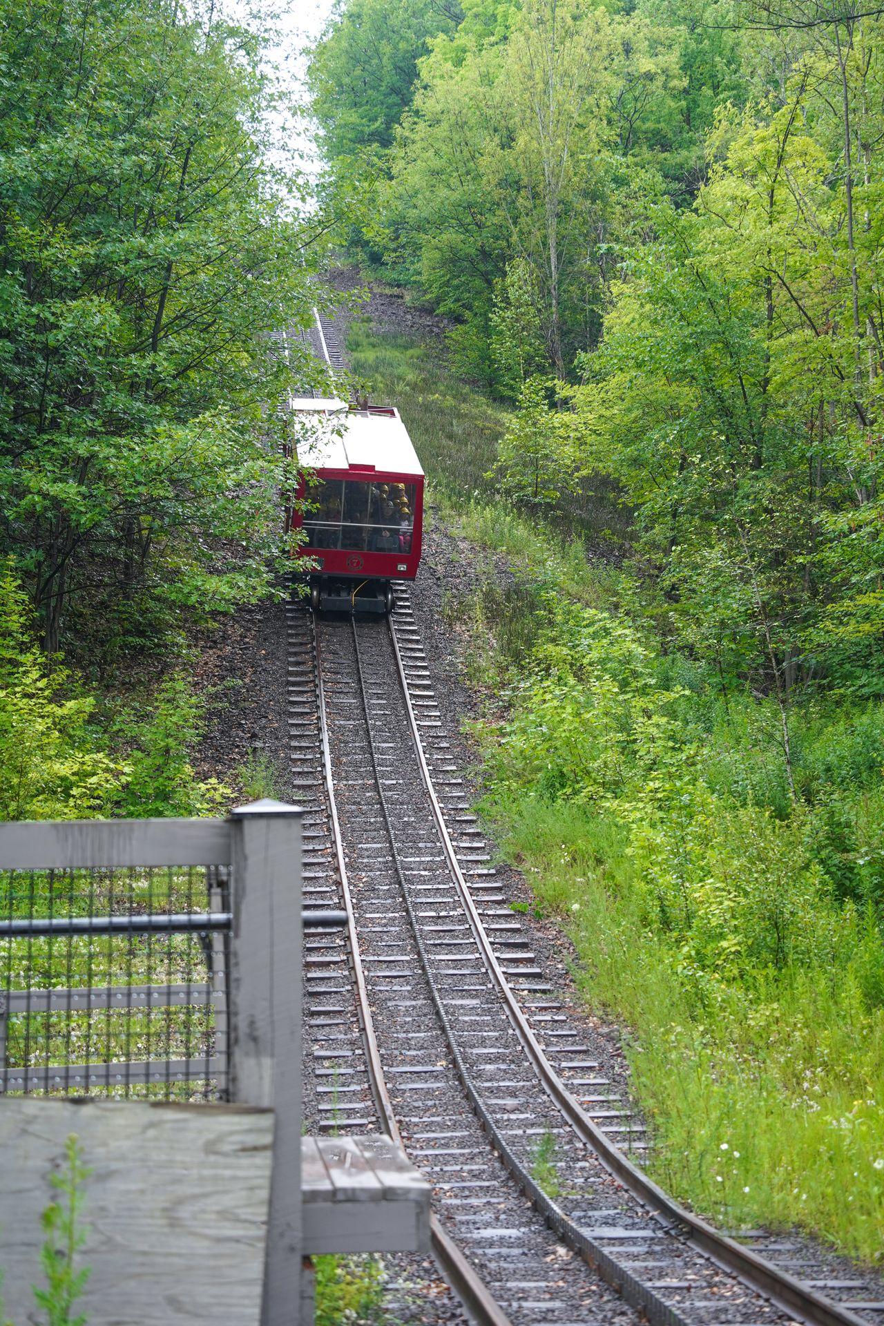 A red traincar coming down a steep track at the Quincy Mine