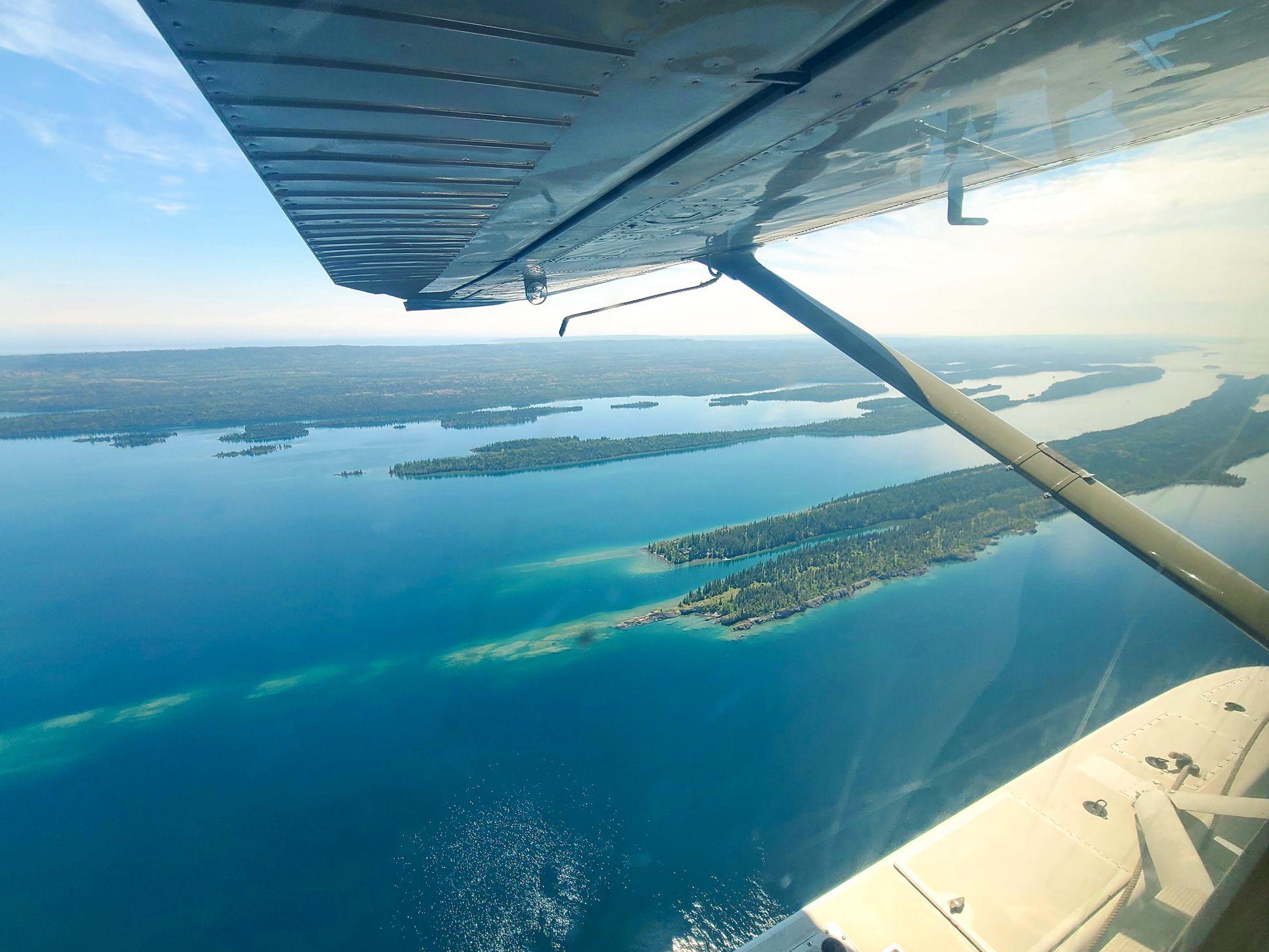 A view looking down at Isle Royale Island from a seaplane. You can see multiple islands with green trees.