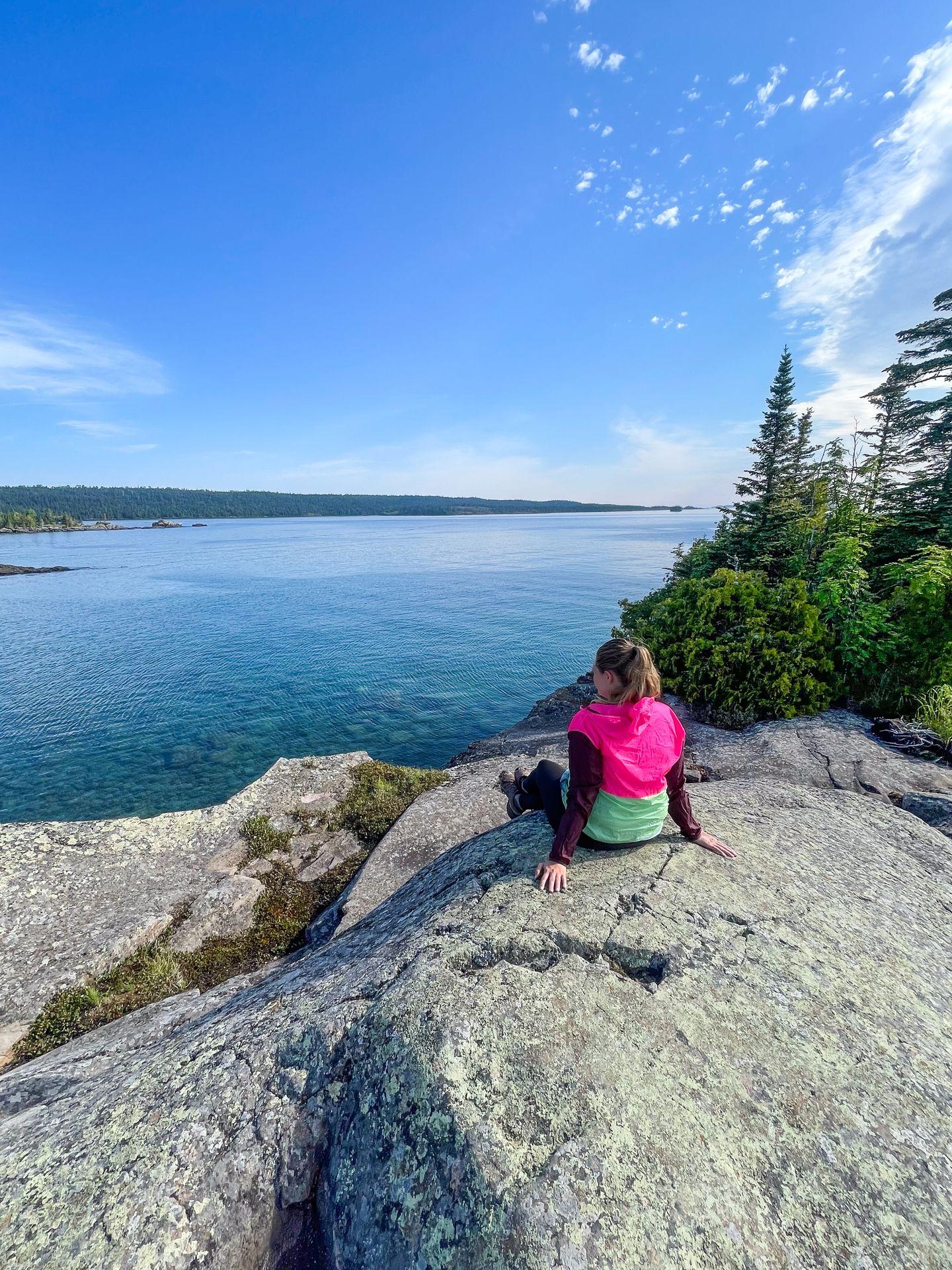 Lydia sitting on rocks and admiring the views from Scoville Point
