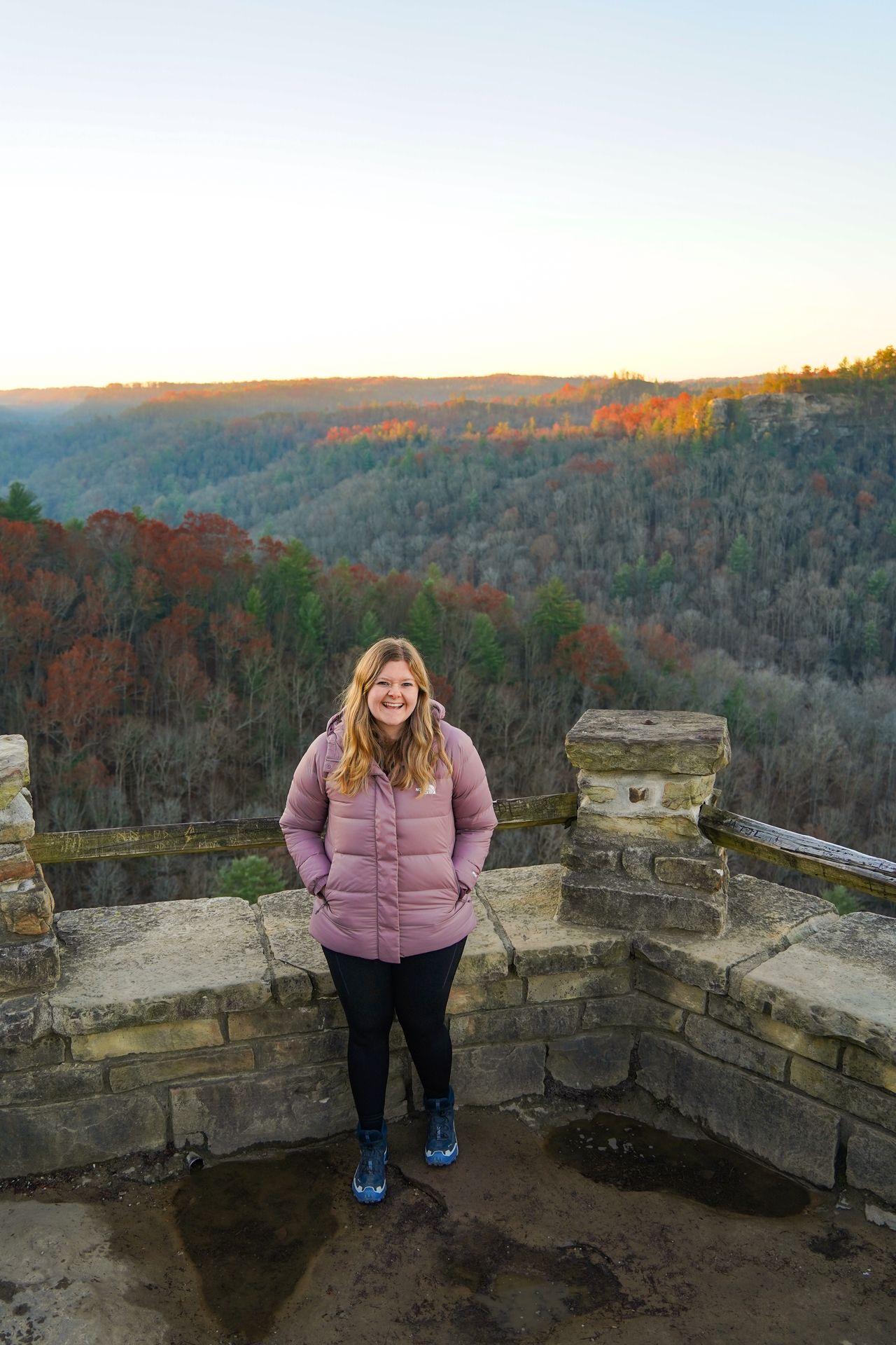 Lydia wearing a purple coat on the Chimney Top Trail in Red River Gorge