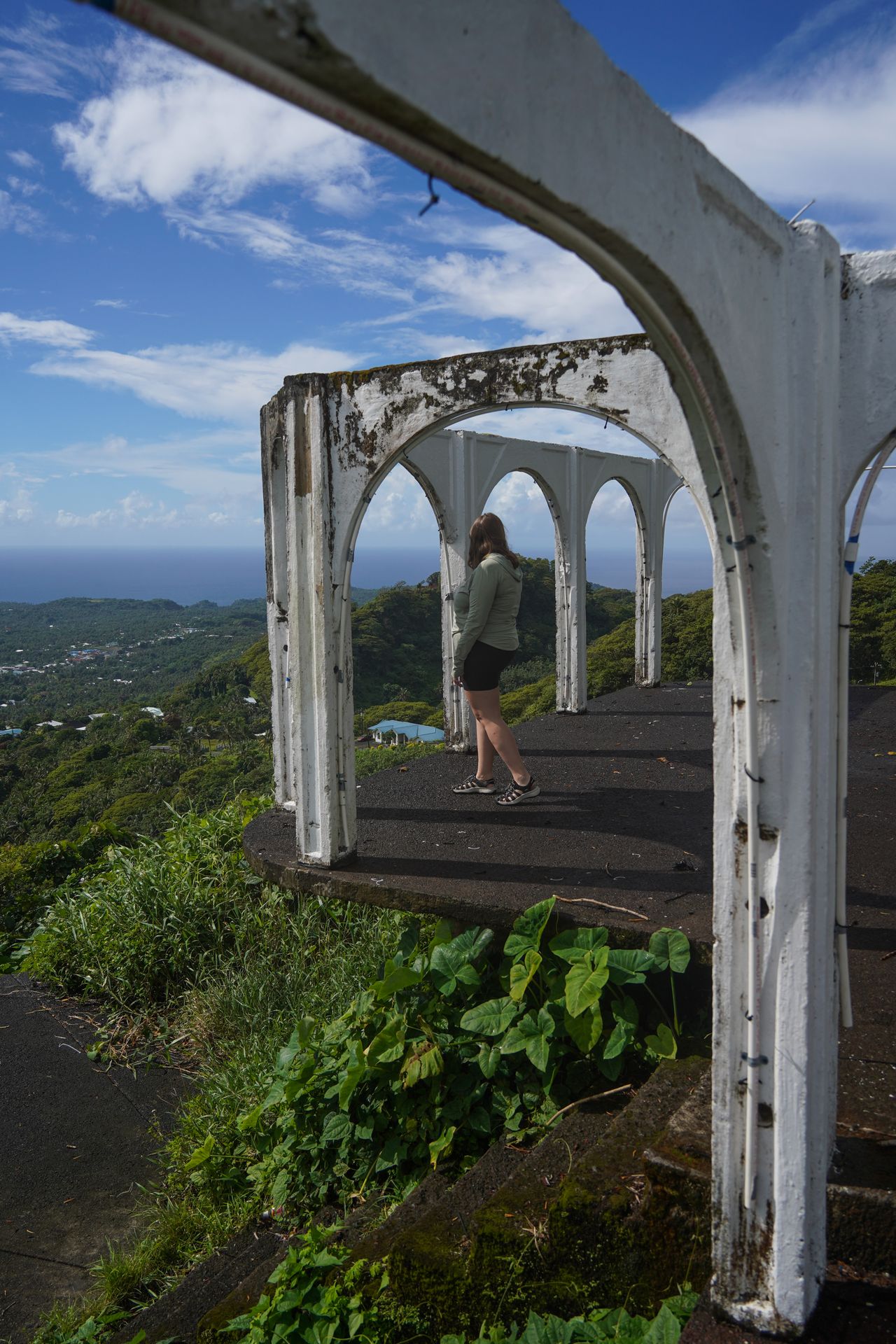 Lydia standing on a platform with ruins of arches